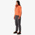 Side shot of Topo Designs Women's Mountain Fleece Pullover in "Rust / brick" pink orange on model.
