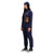 General side shot of model wearing Topo Designs Women's Coverall jumpsuit in "Navy" blue. 