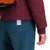 General back model shot of Topo Designs Women's Puffer Primaloft insulated Hoodie jacket in "burgundy" red showing length and cuff.