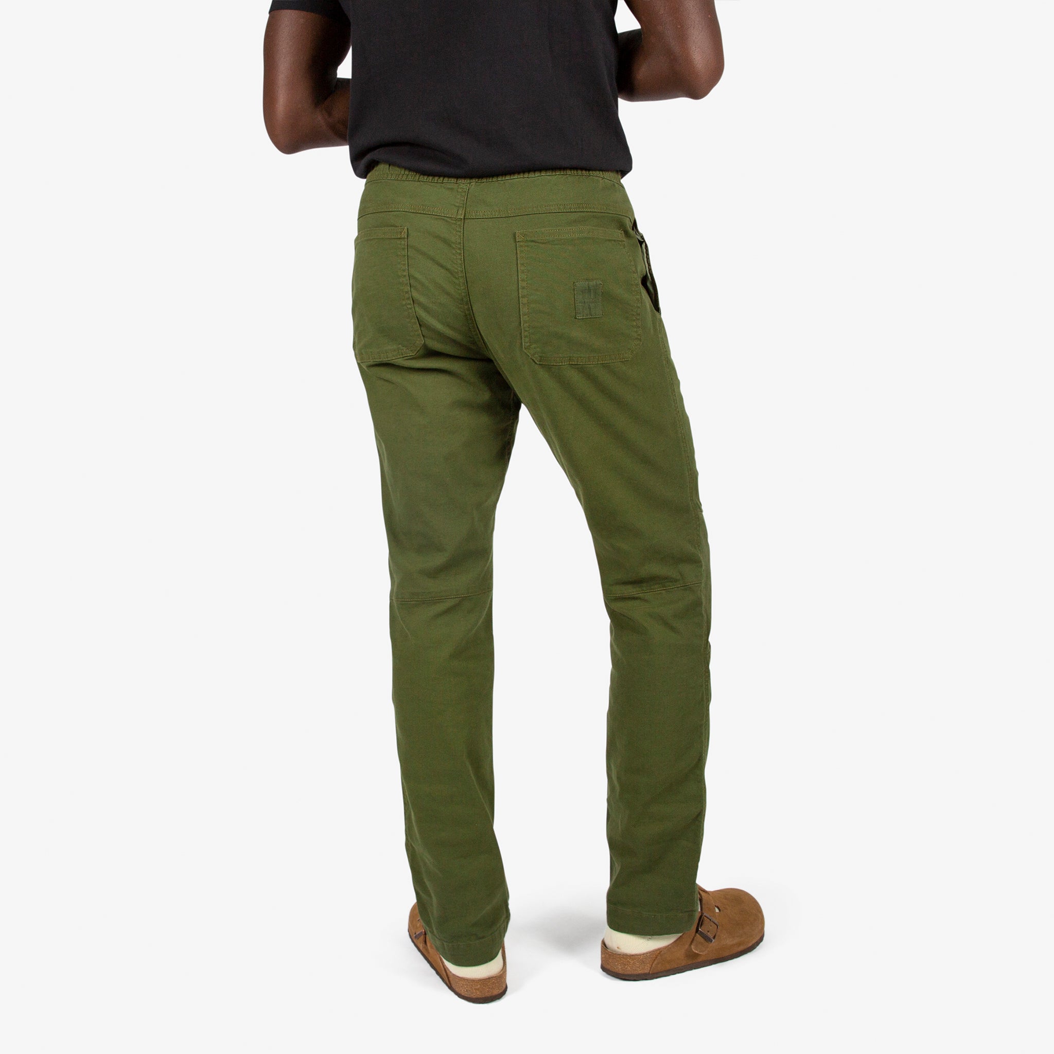 Close-up back model shot of Topo Designs Men's Dirt Shirt & Pants in "Olive" green.