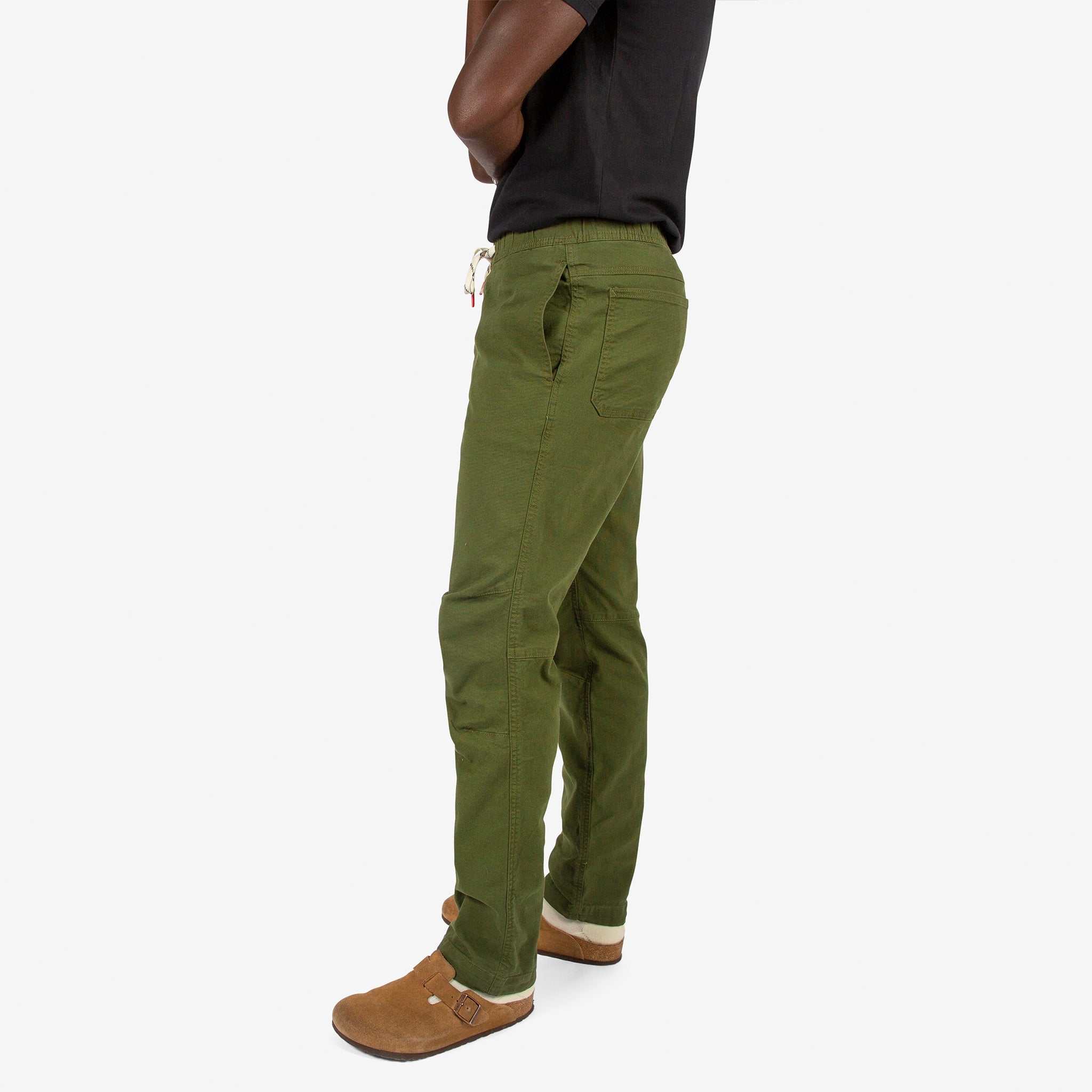 Close-up side model shot of Topo Designs Men's Dirt Shirt & Pants in "Olive" green.