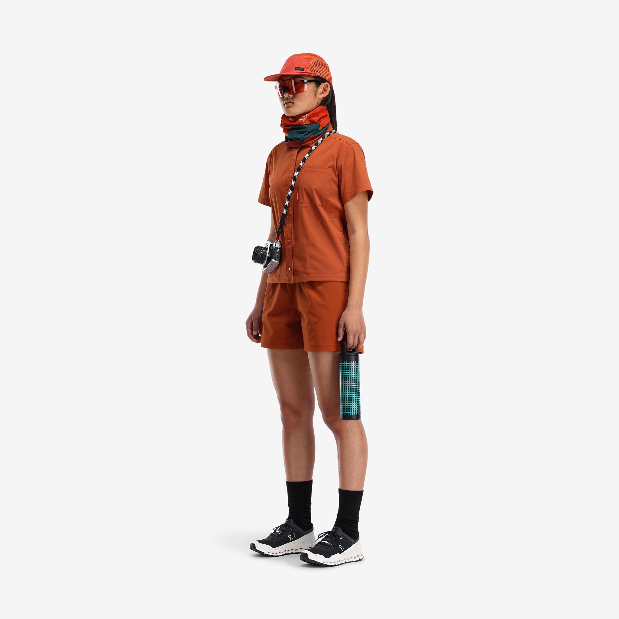 Model wearing Topo Designs Global mesh back Hat in "clay" orange. Unstructured 5-panel flexible brim packable hat.
