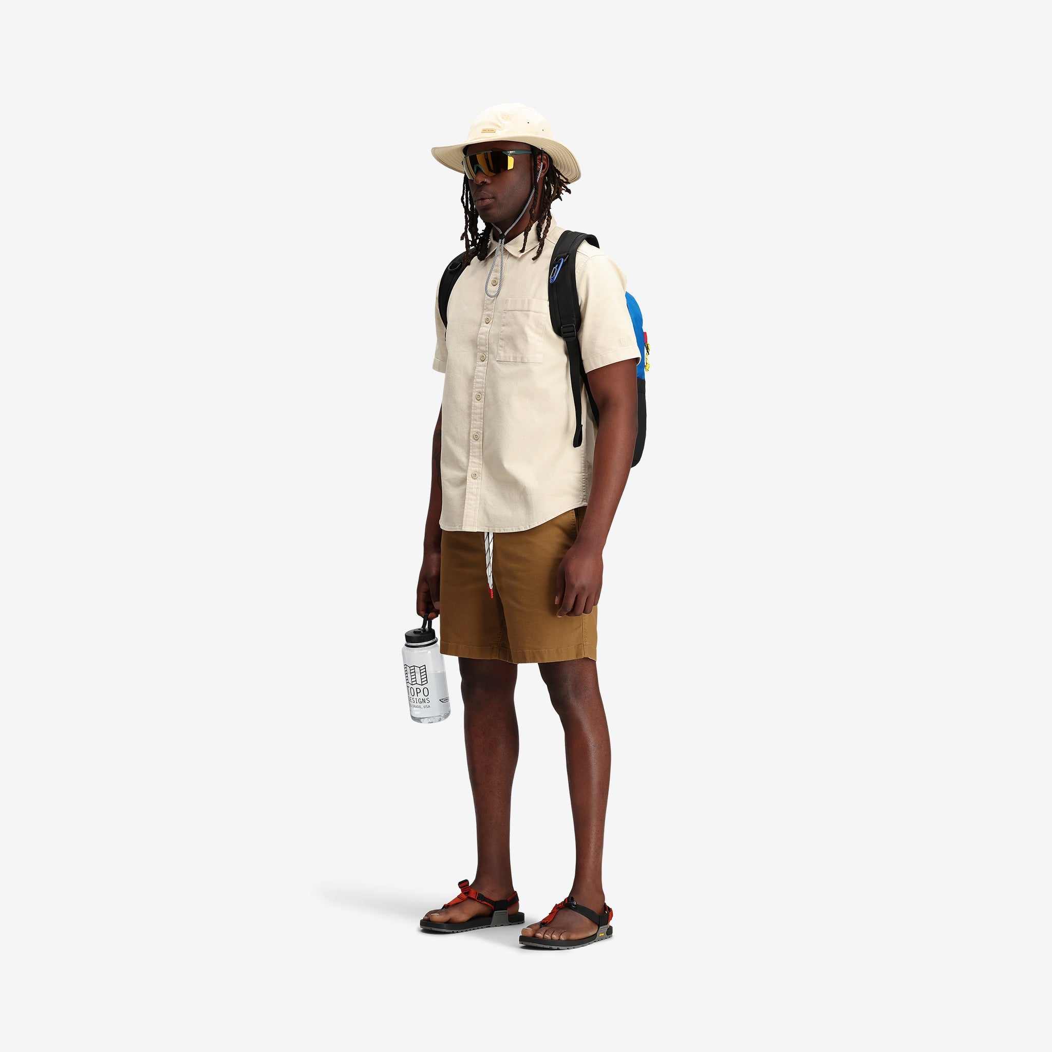 On model front shot of Topo Designs Men's drawstring Dirt Shorts 100% organic cotton in "Dark Khaki" tan brown.