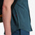 Model shot showing the zip up pocket feature of Topo Designs Men's Global Shirt Short Sleeve 30+ UPF rated travel shirt in "Pond Blue".