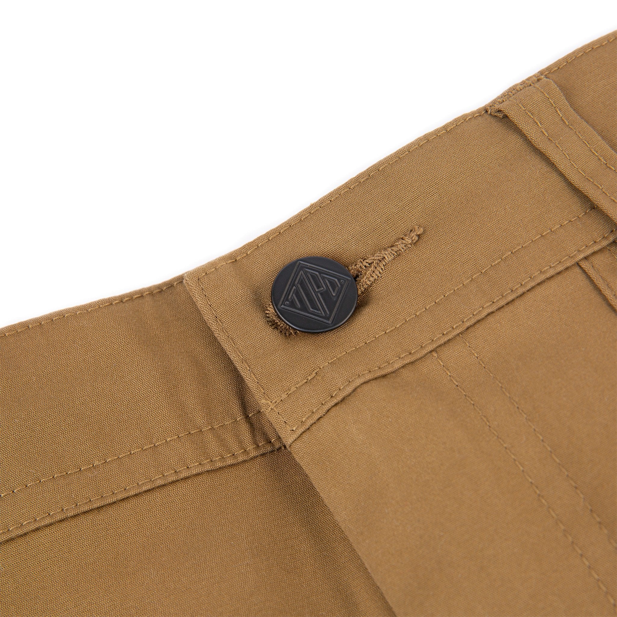 Topo Designs Men's Global Pants lightweight cotton nylon travel pants in Dark Khaki brown showing logo hardware on fly.