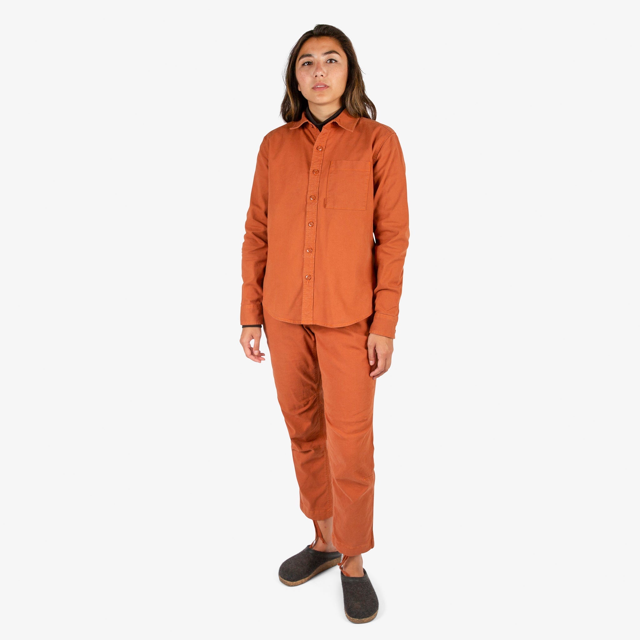 Front model shot of Topo Designs Women's Dirt Shirt & Pants in "Brick" orange. Show on "Peppercorn" & "Black"