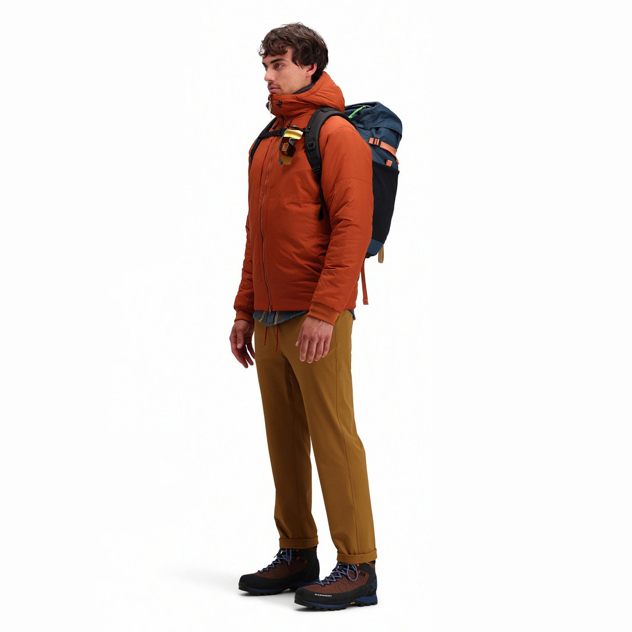 Side model shot of Topo Designs Mountain Puffer Primaloft insulated Hoodie jacket in "Brick" orange