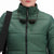 Front model shot of Topo Designs Women's Puffer recycled insulated Jacket in "Forest" green showing zipper, collar, and chest logo.