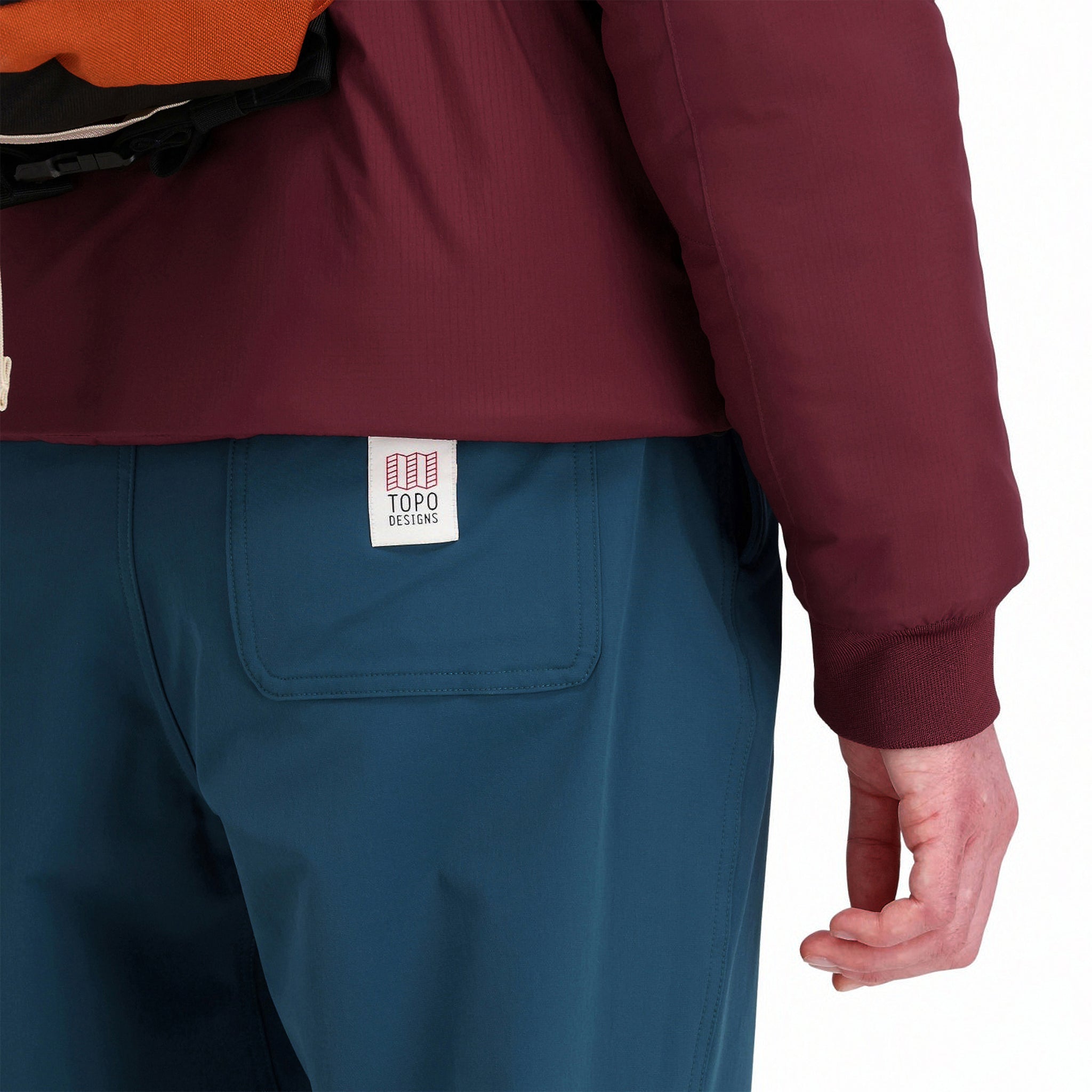 General back model shot of Topo Designs women's boulder lightweight hiking and climbing pants in "pond blue" showing logo patch on back pocket.