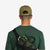 Back of Topo Designs 5 Panel Snapback Hat 4 Square embroidered logo on olive green on model.