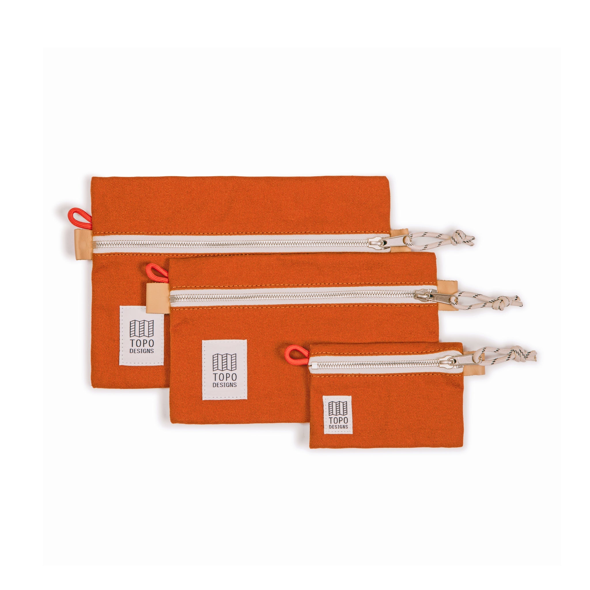 Collection of 3 sizes of Topo Designs Accessory Bags in clay orange canvas.