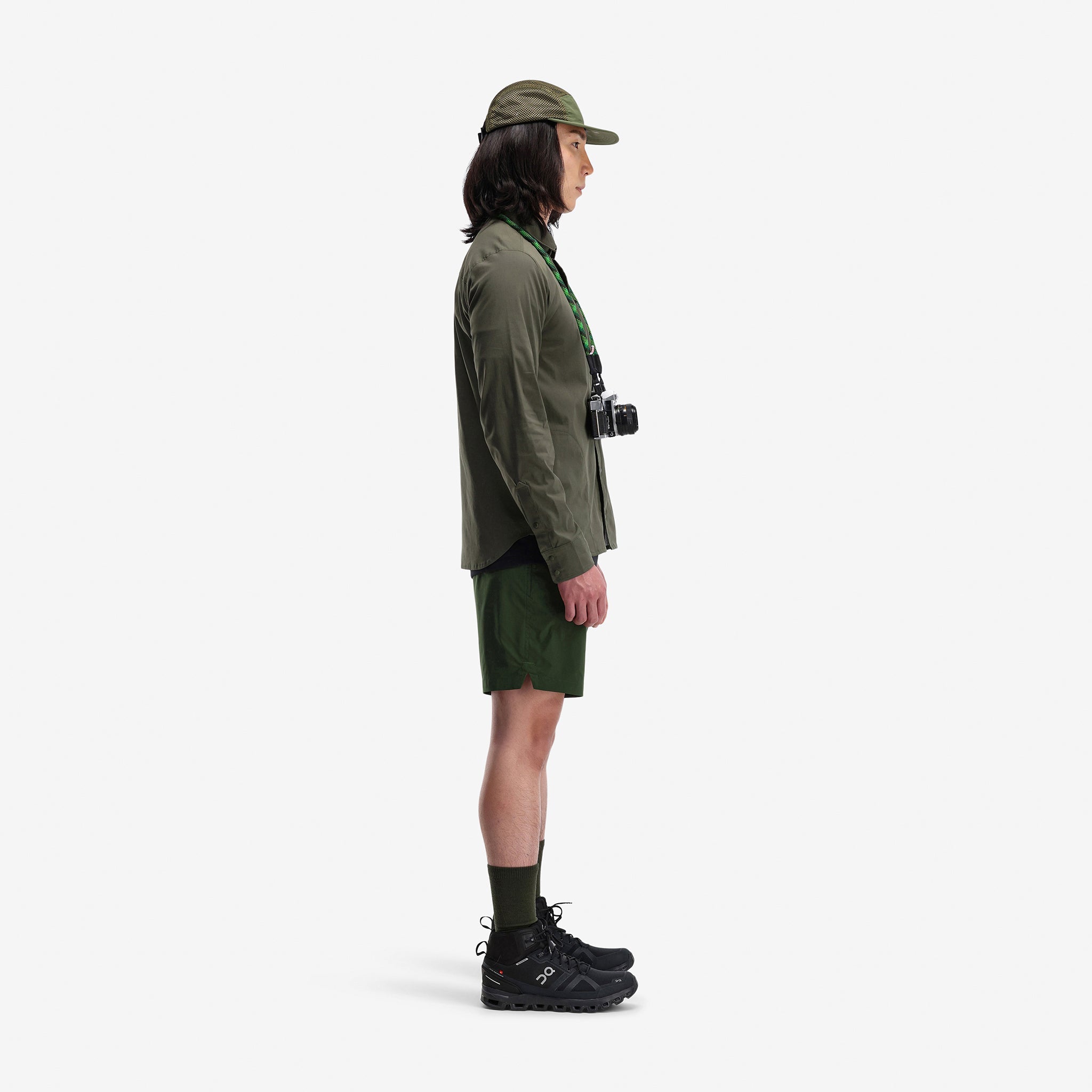 Side model shot of Topo Designs Men's Global lightweight quick dry travel Shorts in "Olive" green.