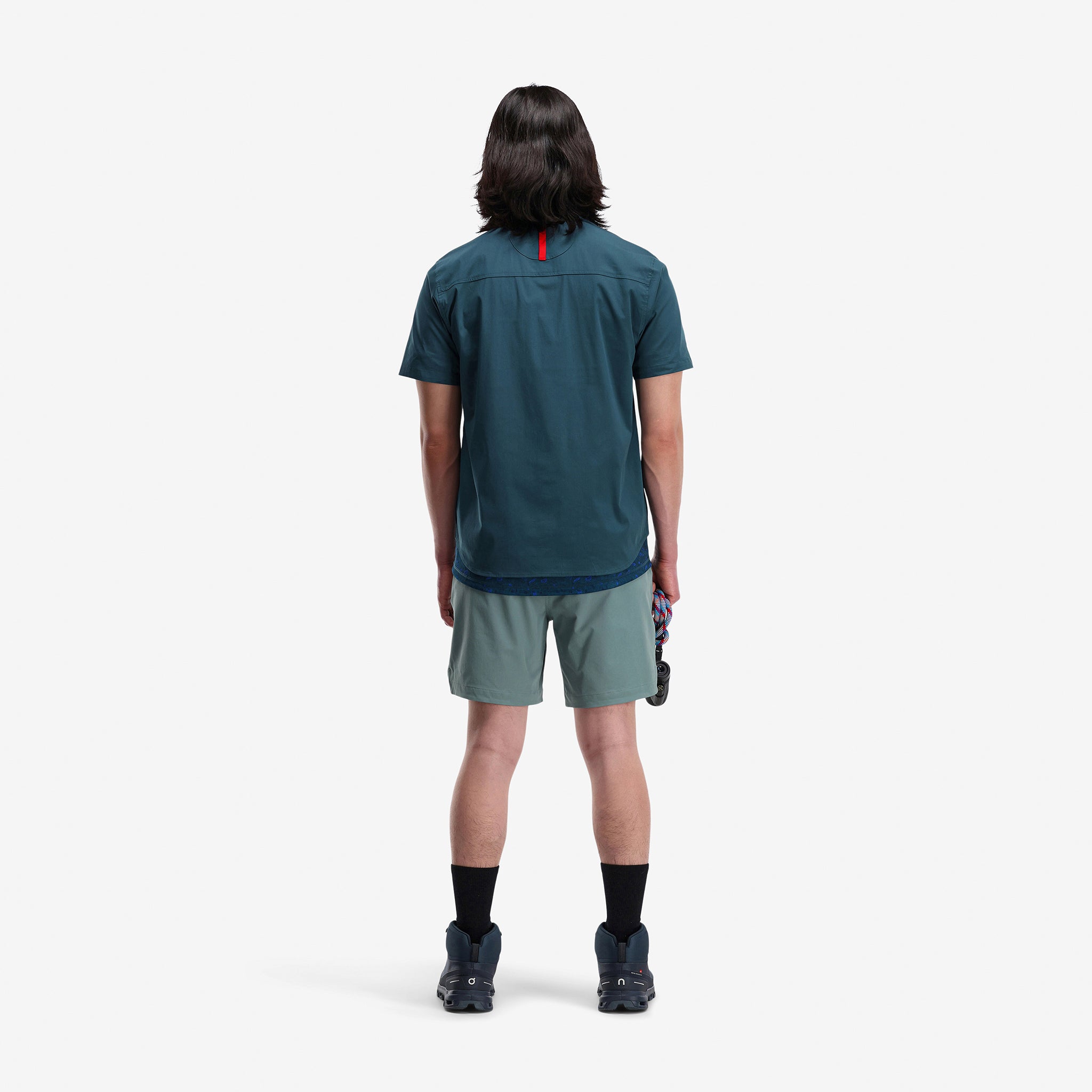 Back model shot of Topo Designs Men's Global lightweight quick dry travel Shorts in "Slate" blue gray. Show on "pond blue" and "brick".