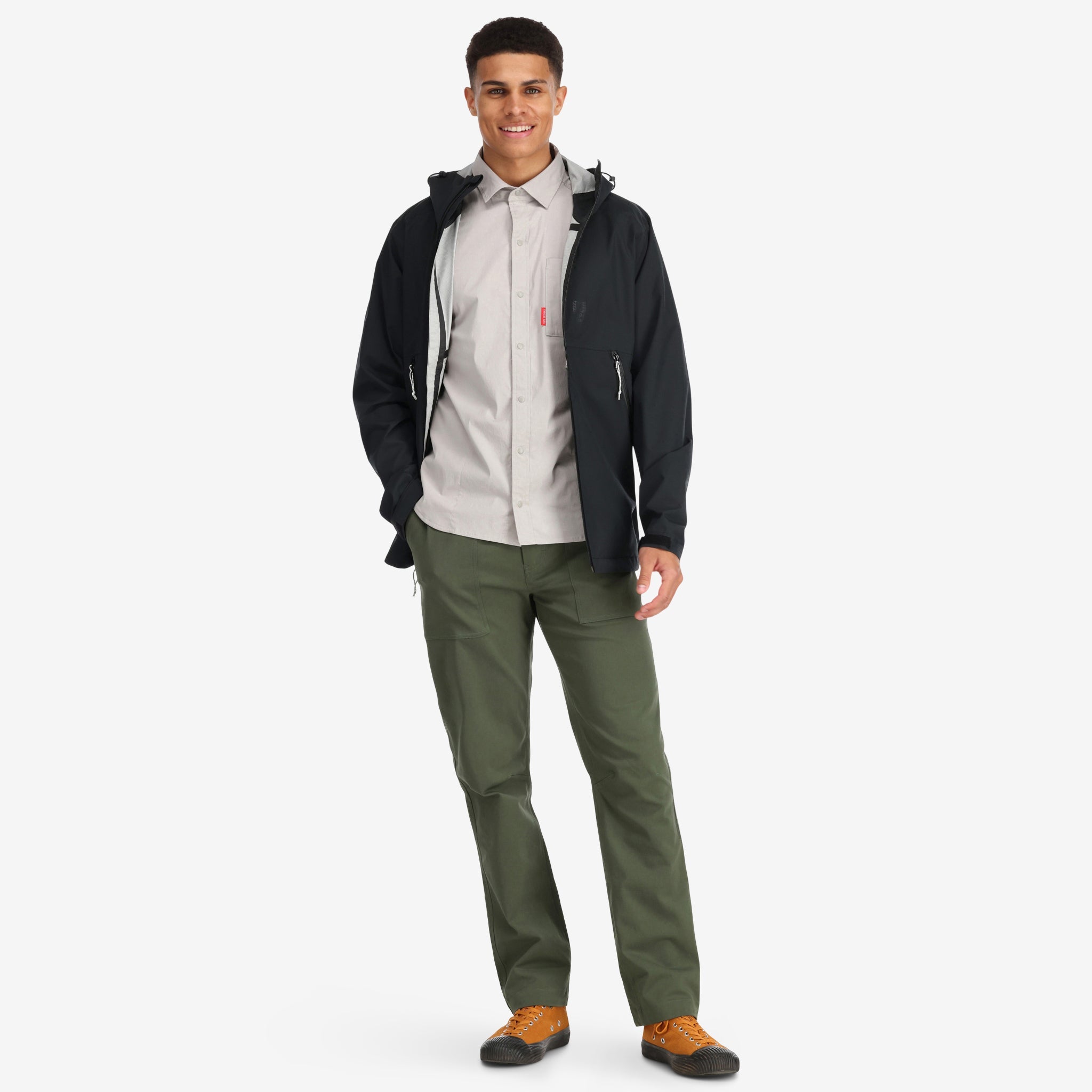 Model wearing Topo Designs Men's Global Pants lightweight cotton nylon travel pants in olive green.