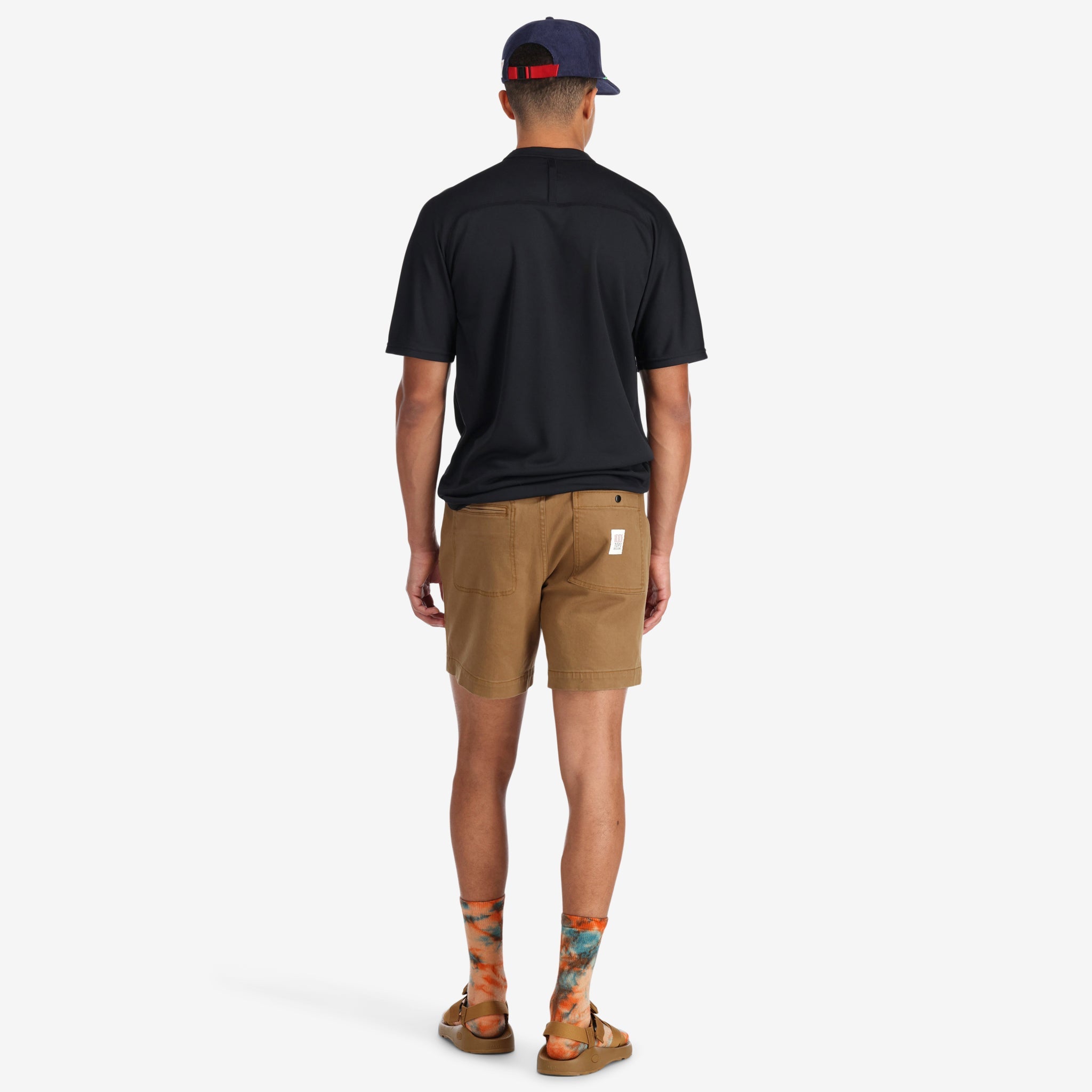 Back of model wearing Topo Designs Men's Mountain organic cotton Shorts in Dark Khaki brown.