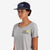 General shot, left side, of model wearing Topo Designs Corduroy Trucker Hat with Sunrise graphic patch on navy blue.