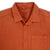 General shot of Topo Designs Men's Short Sleeve Dirt Shirt in Brick orange showing close-up of collar, inside tag, buttons, and check pocket.