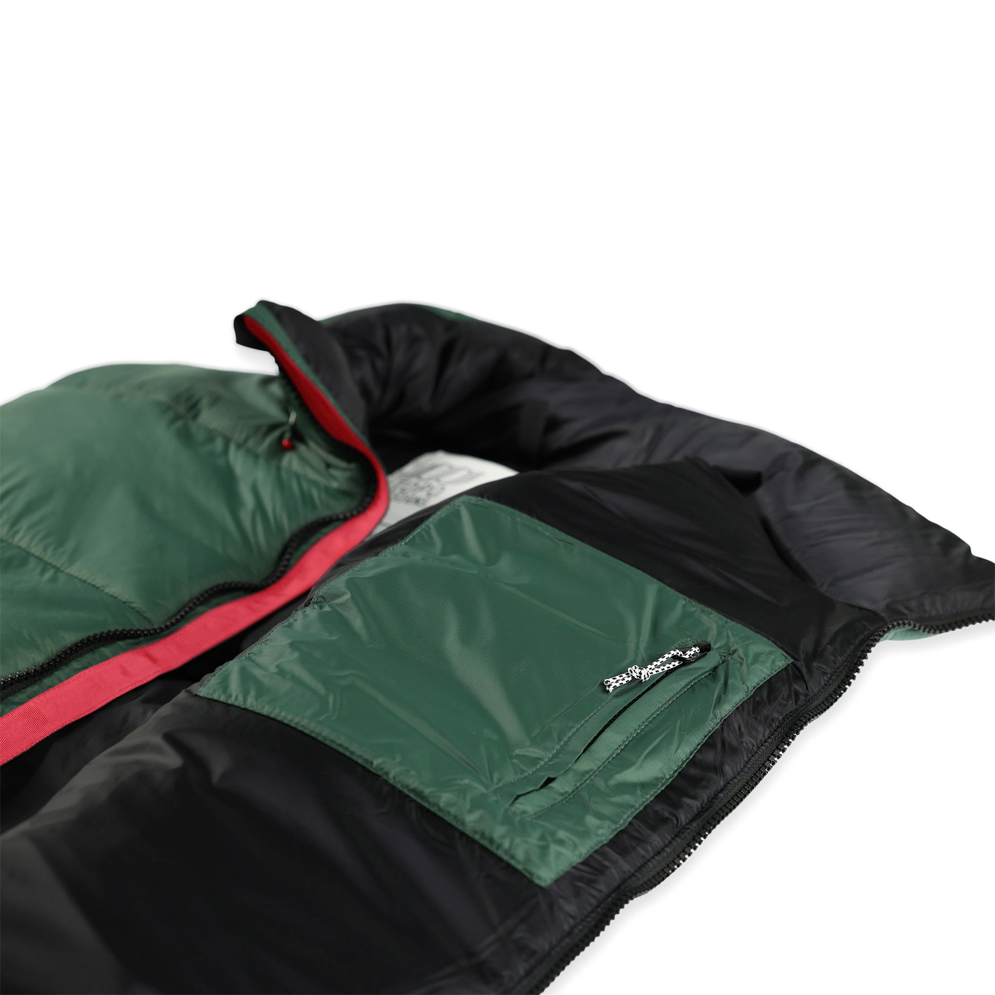 Detailaufnahme der Reißverschlusstaschen an der Topo Designs Herren Mountain Puffer Isolationsweste in "Forest" grün mit Reißverschlusstasche und Kordelzug am unteren Saum.