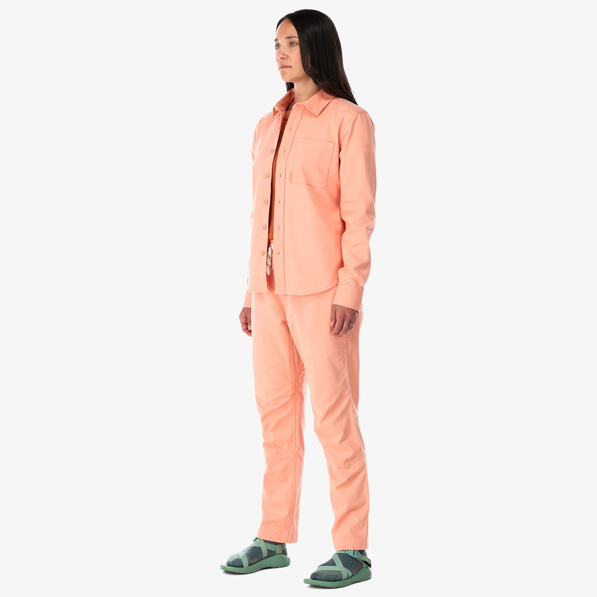  Topo Designs Damen Dirt Shirt langärmeliges Button-up aus Stretch-Baumwolle in "peach" pink auf der Modellseite.