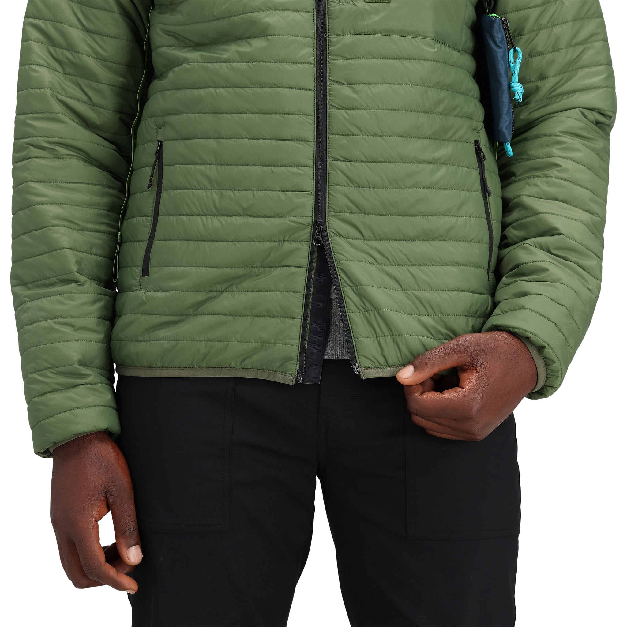 Allgemeine Detailaufnahme des Doppelreißverschlusses am Model, das die Topo Designs Herren Global Puffer packbare recycelte isolierte Hoodie Jacke in "olive" grün trägt.