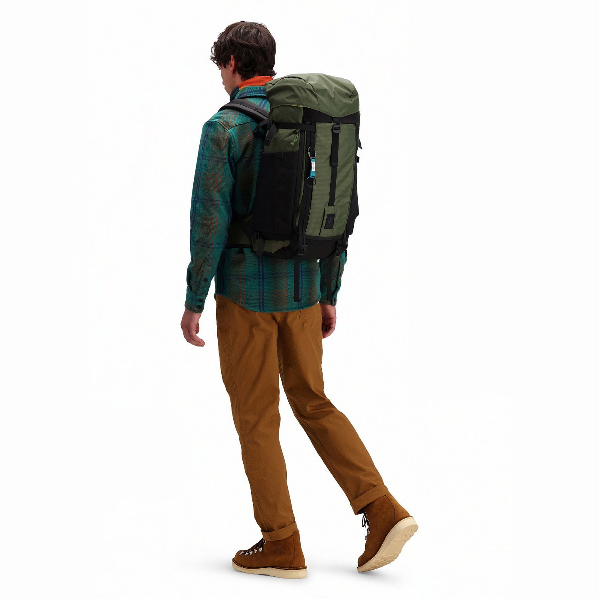 Das Model trägt den Topo Designs Mountain Pack 28L Wanderrucksack mit externem Laptopfach aus leichtem, recyceltem "olivgrünem" Nylon.