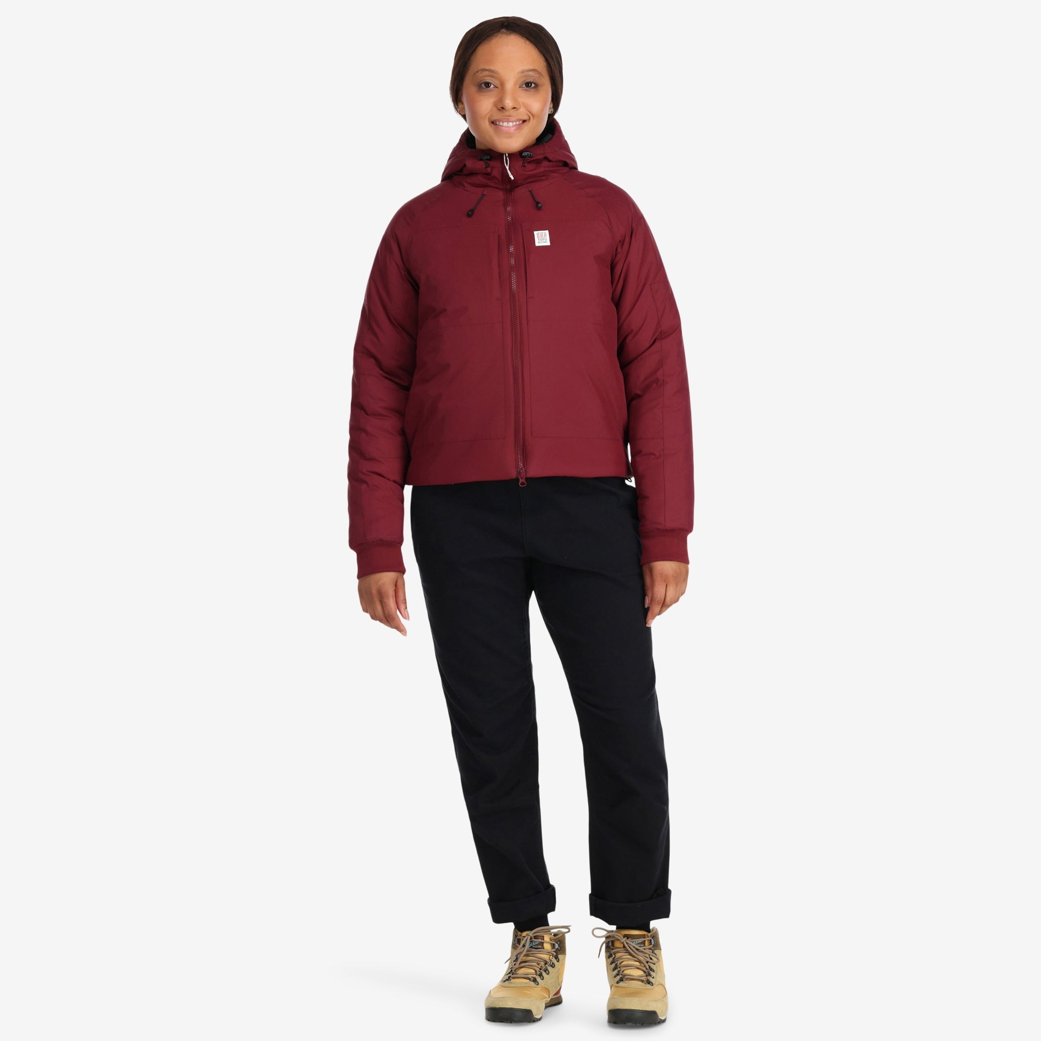 Frontmodell der Topo Designs Damen Puffer Primaloft insulated Hoodie Jacke in "burgundy" rot.