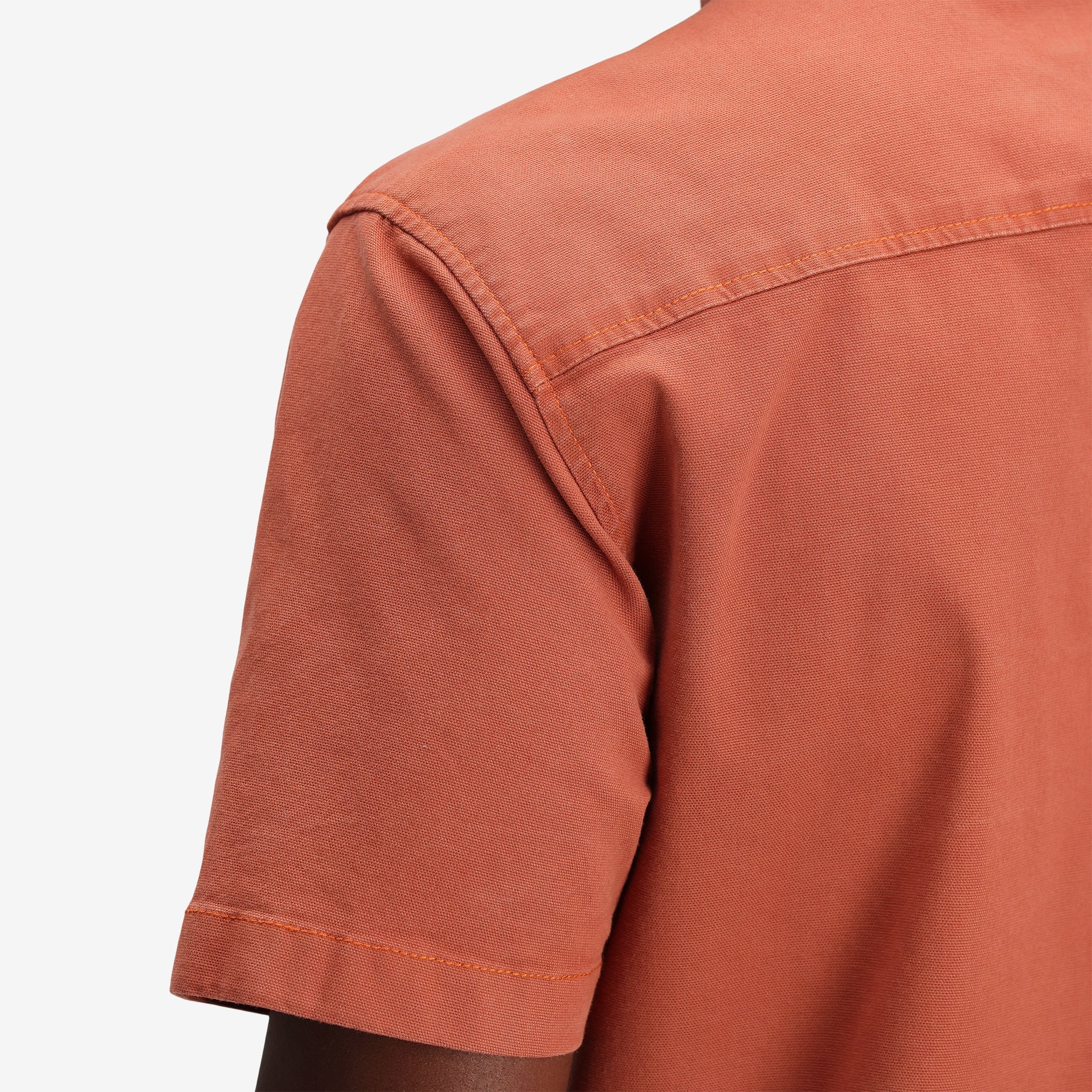 Gesamtaufnahme des Topo Designs Herren Short Sleeve Dirt Shirt in "Brick" orange in Nahaufnahme.