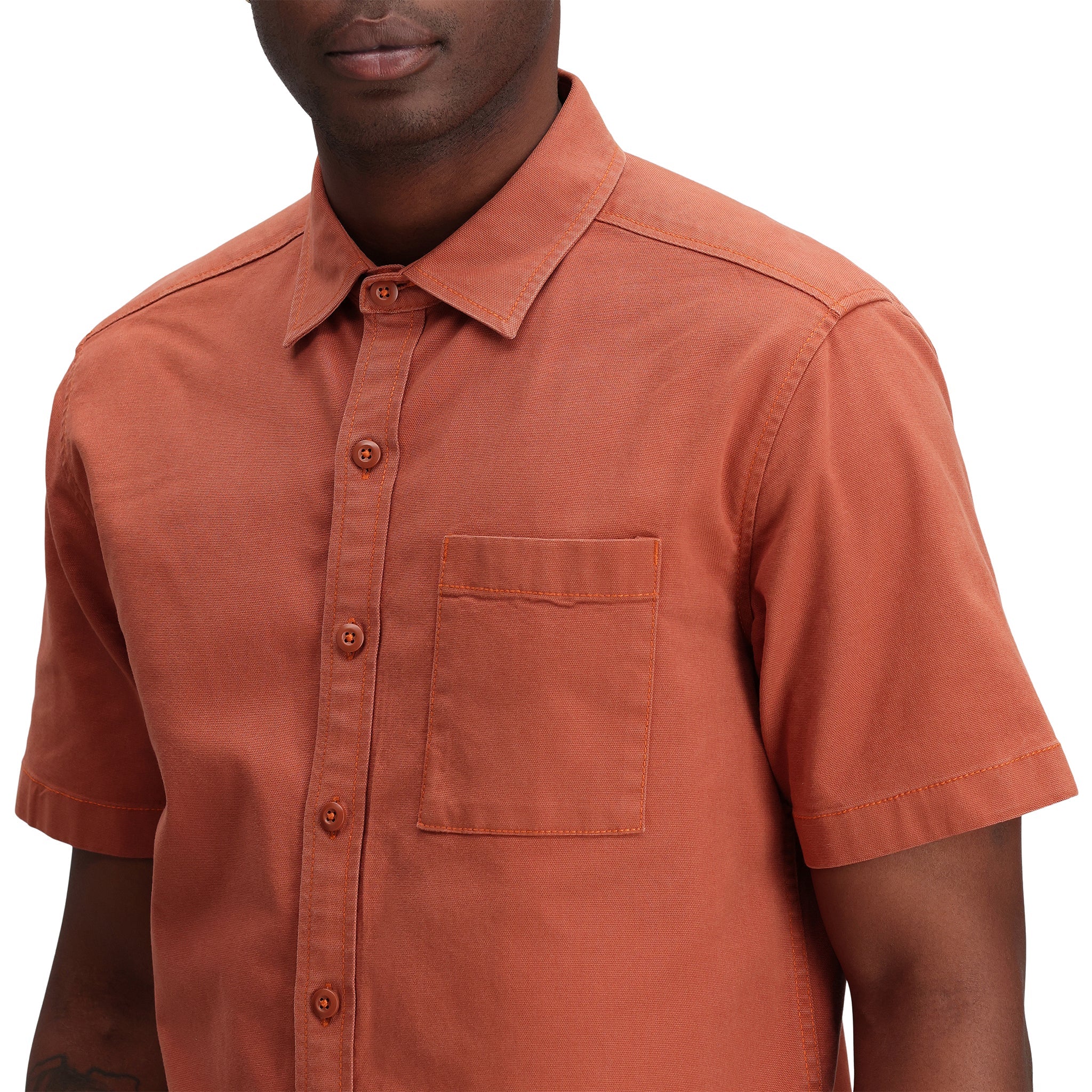 Gesamtaufnahme des Topo Designs Herren Short Sleeve Dirt Shirt in "Brick" orange in Nahaufnahme.