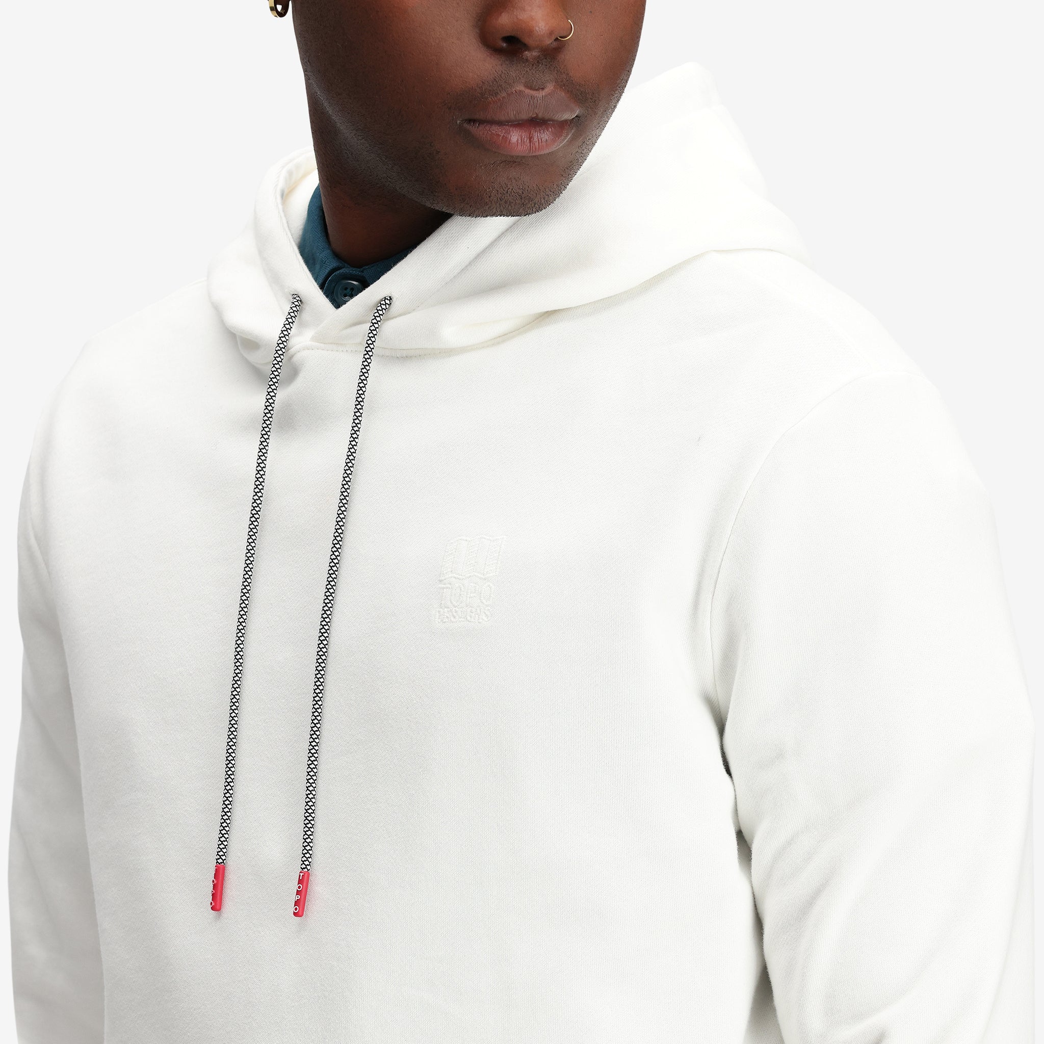 Detailaufnahme des Topo Designs Herren Dirt Hoodie 100% Bio-Baumwolle French Terry Sweatshirt in "natural" weiß.