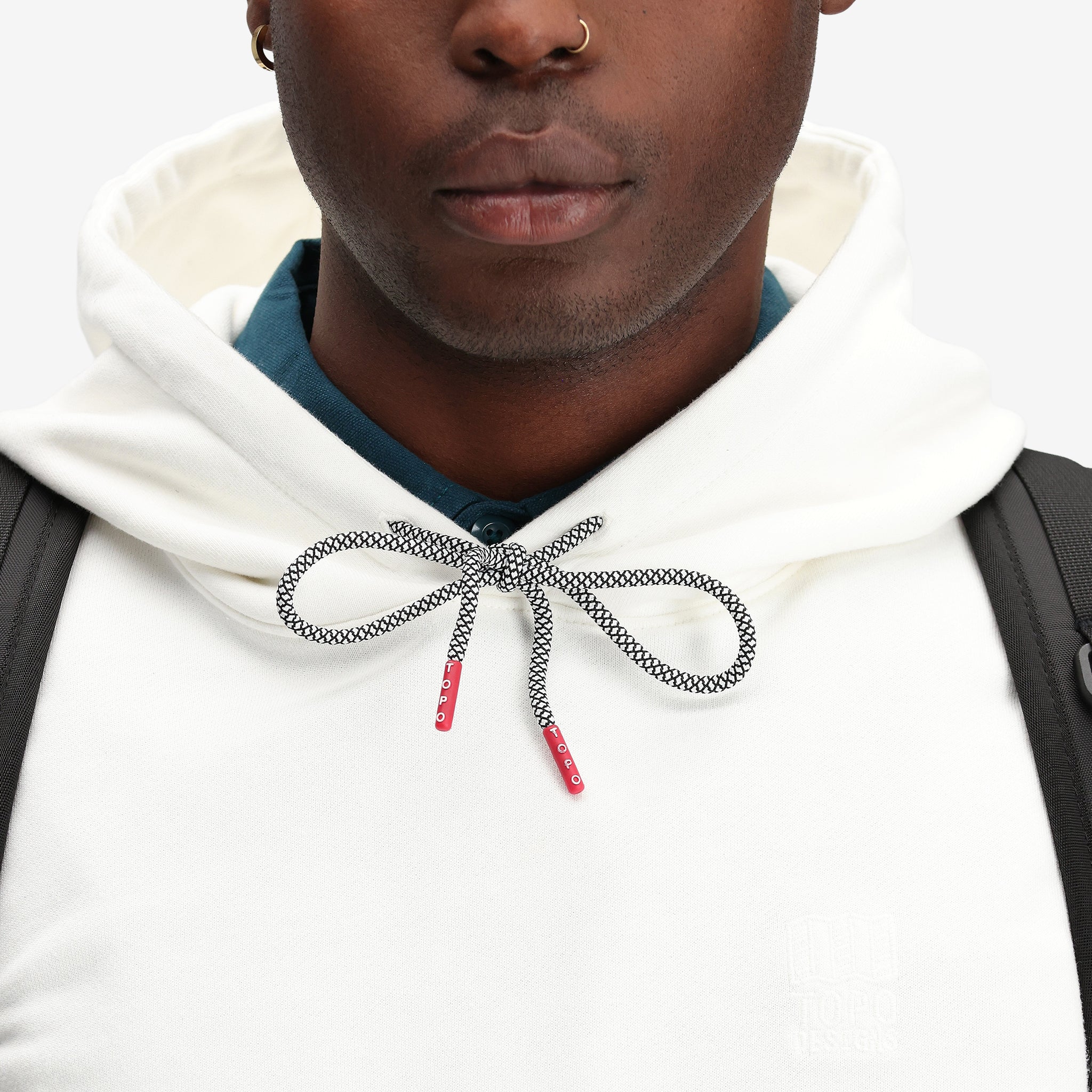 Detailaufnahme des Topo Designs Herren Dirt Hoodie 100% Bio-Baumwolle French Terry Sweatshirt in "natural" weiß.