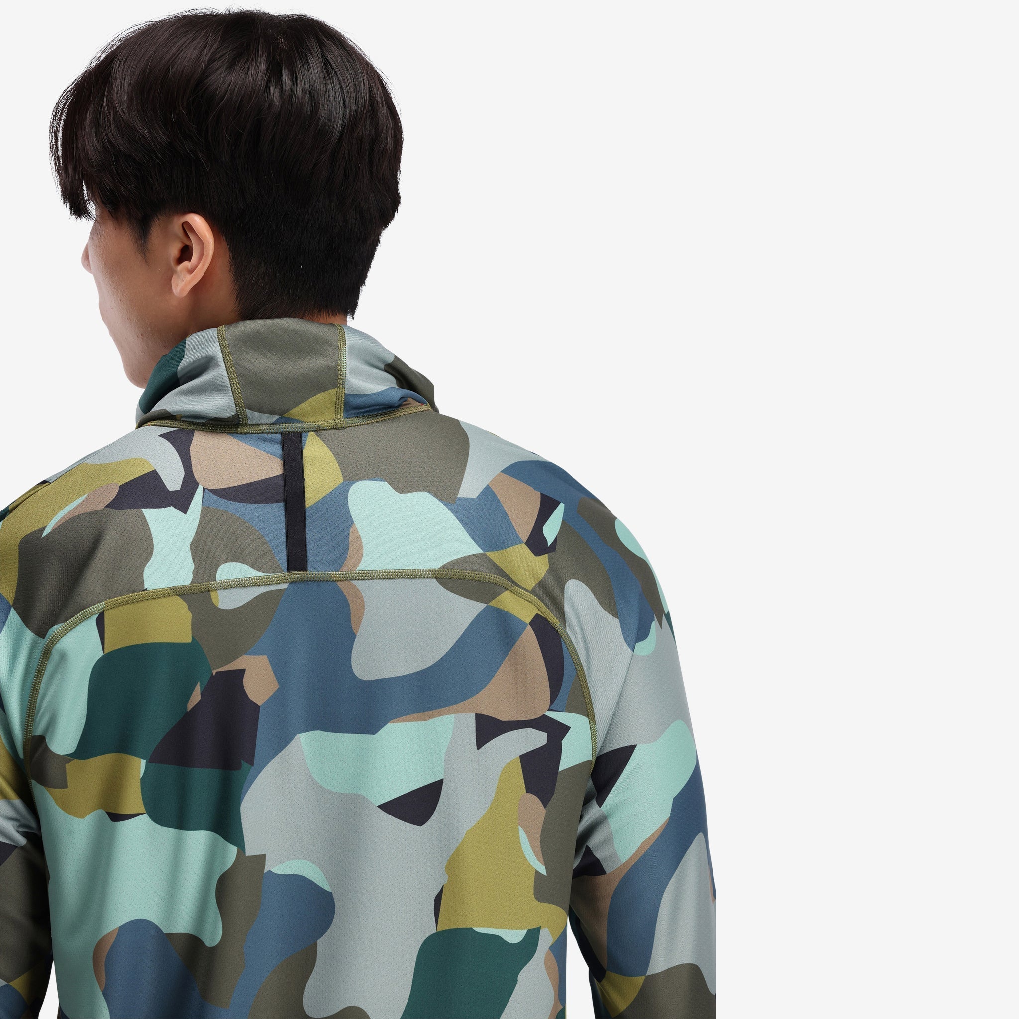 Allgemein auf dem Modell in der Nähe Foto der Rückseite des Topo Designs Herren River Hoodie 30+ UPF Feuchtigkeitstransport schnell trocknend Top in "Green Camo" grün.