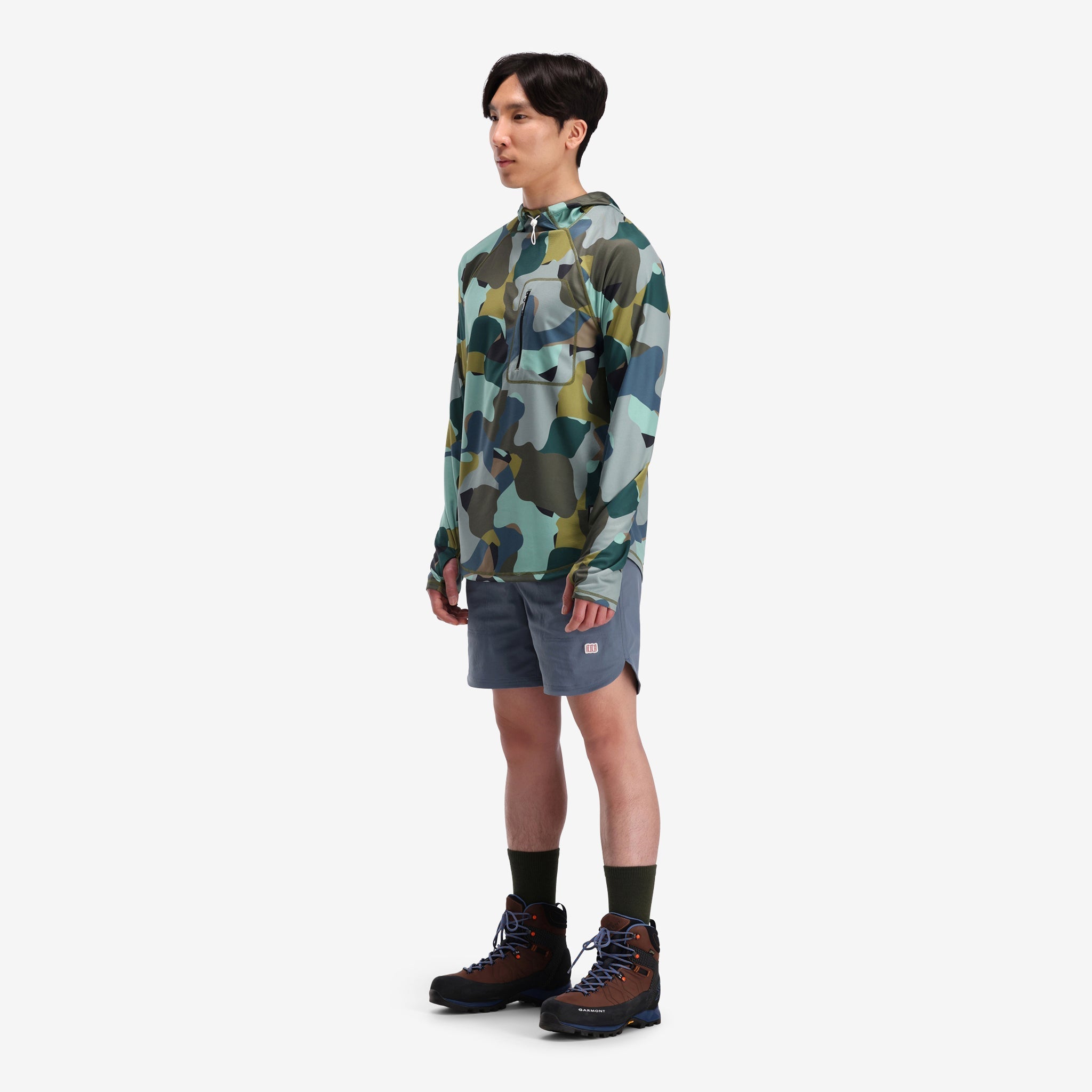 Allgemeine Seitenaufnahme des Topo Designs Herren River Hoodie 30+ UPF feuchtigkeitsableitendes, schnell trocknendes Oberteil in "Green Camo" grün.