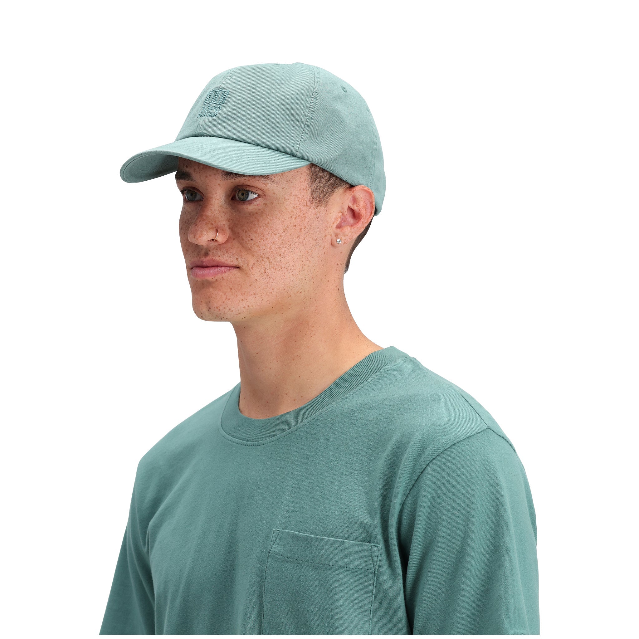 Allgemeine Seitenaufnahme des Modells Topo Designs Dirt Ballcap in "Sea Pine".