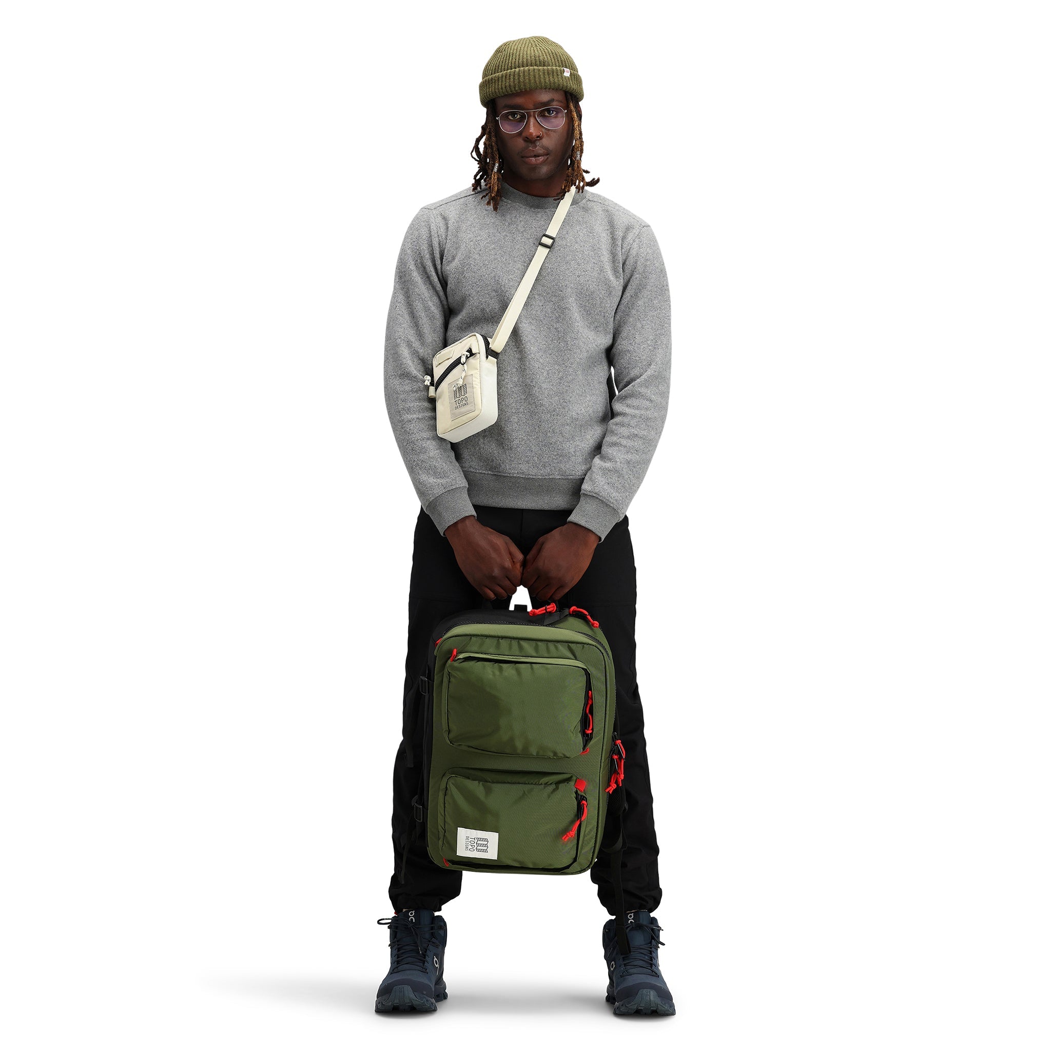 Allgemeine Modellaufnahme der Vorderseite des Topo Designs Global Briefcase Cabrio-Laptop-Reiserucksack in "Olive" grünem Nylon.