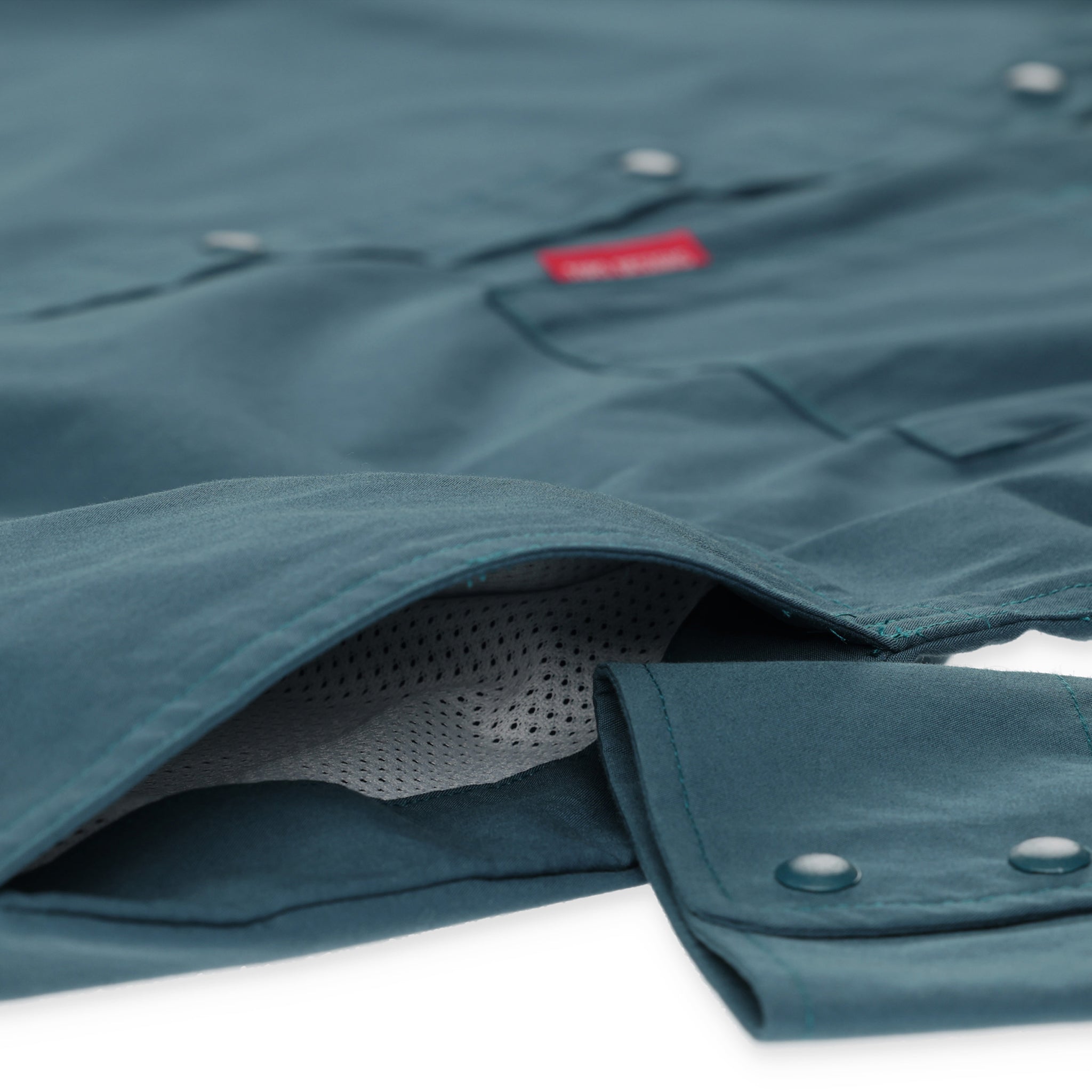 Detailaufnahme der seitlichen Eingrifftaschen am Topo Designs Herren Global Shirt Langarm-Leichtgewicht-Reiseshirt in "Pond Blue"