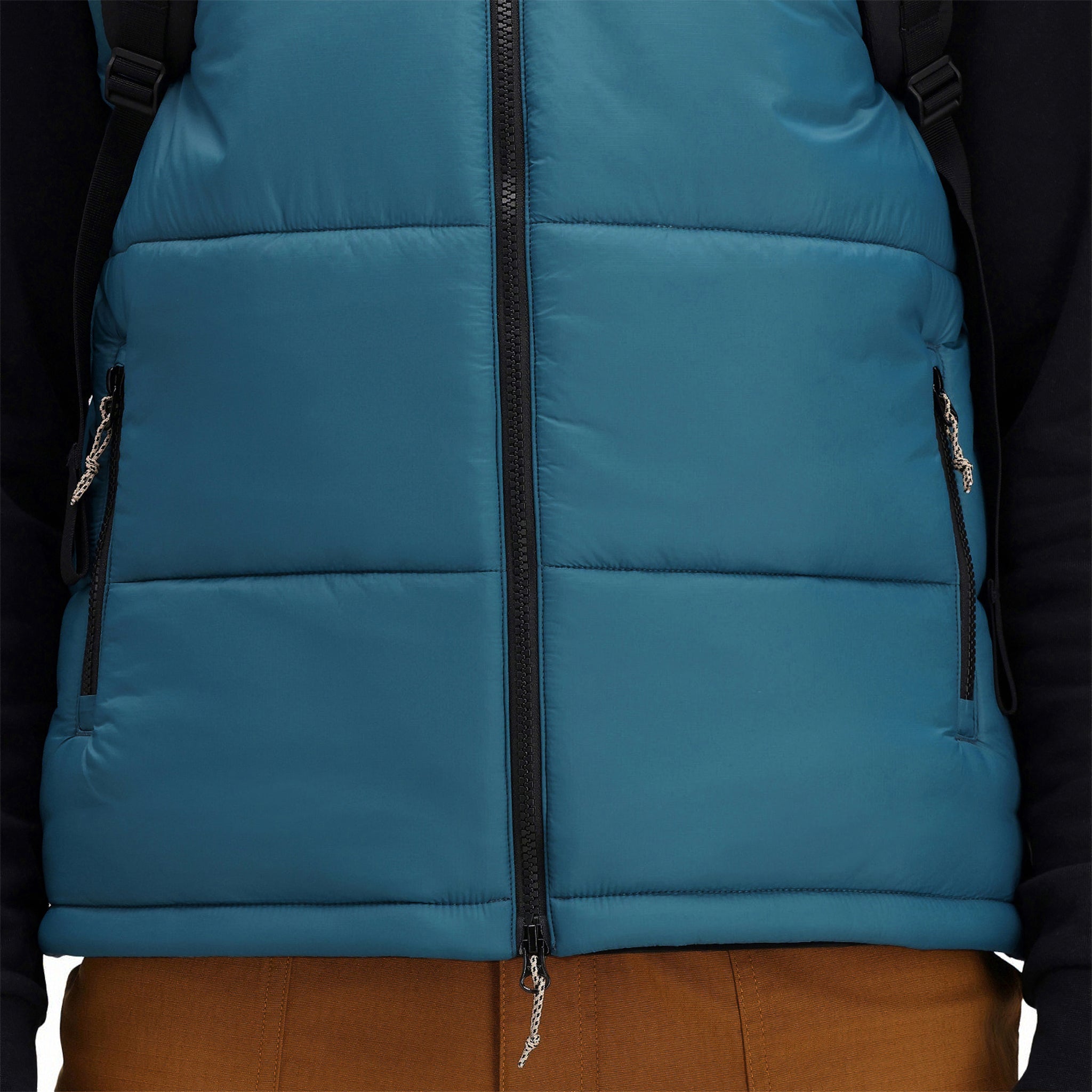 Vordere Modellaufnahme der Topo Designs Herren Mountain Puffer recycelten isolierten Weste in "Pond Blue" mit Reißverschlusshandtaschen.