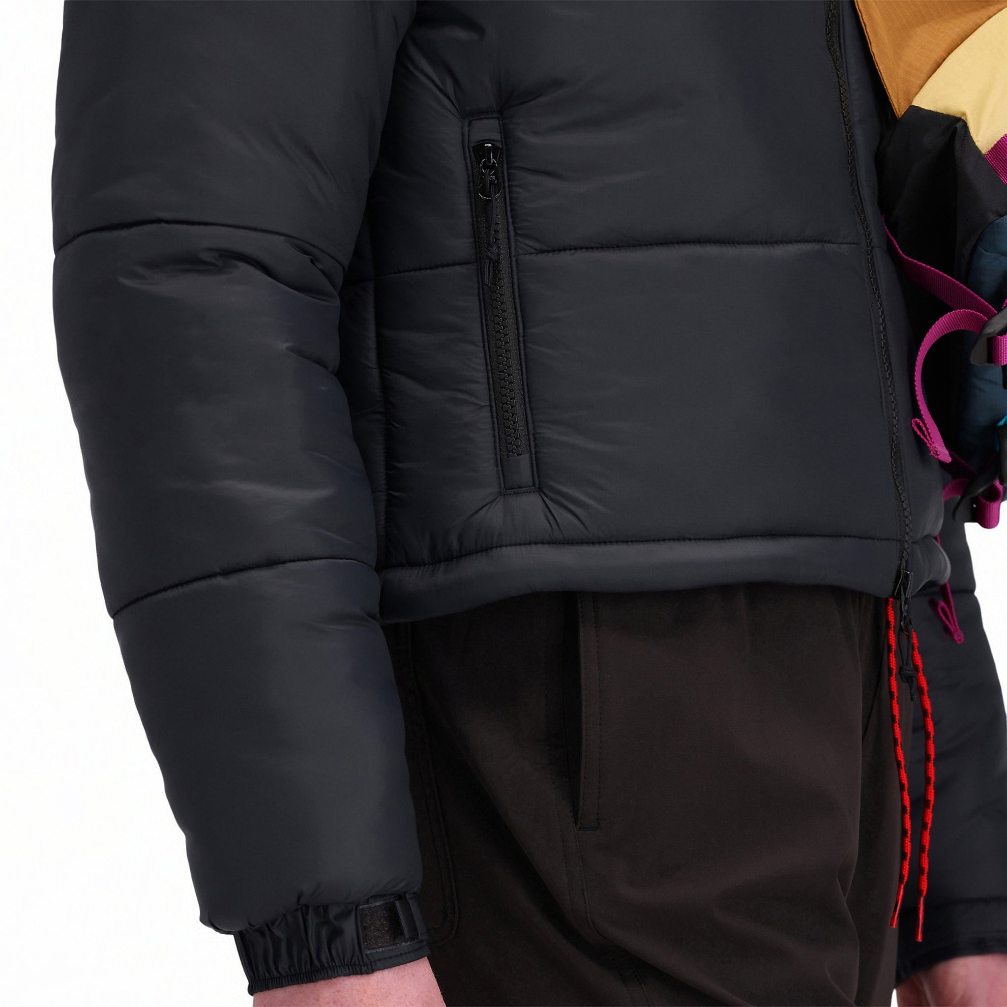 Vordere Modellaufnahme der Topo Designs Damen Puffer recycled insulated Jacket in "Black" mit Handreißverschlusstaschen.