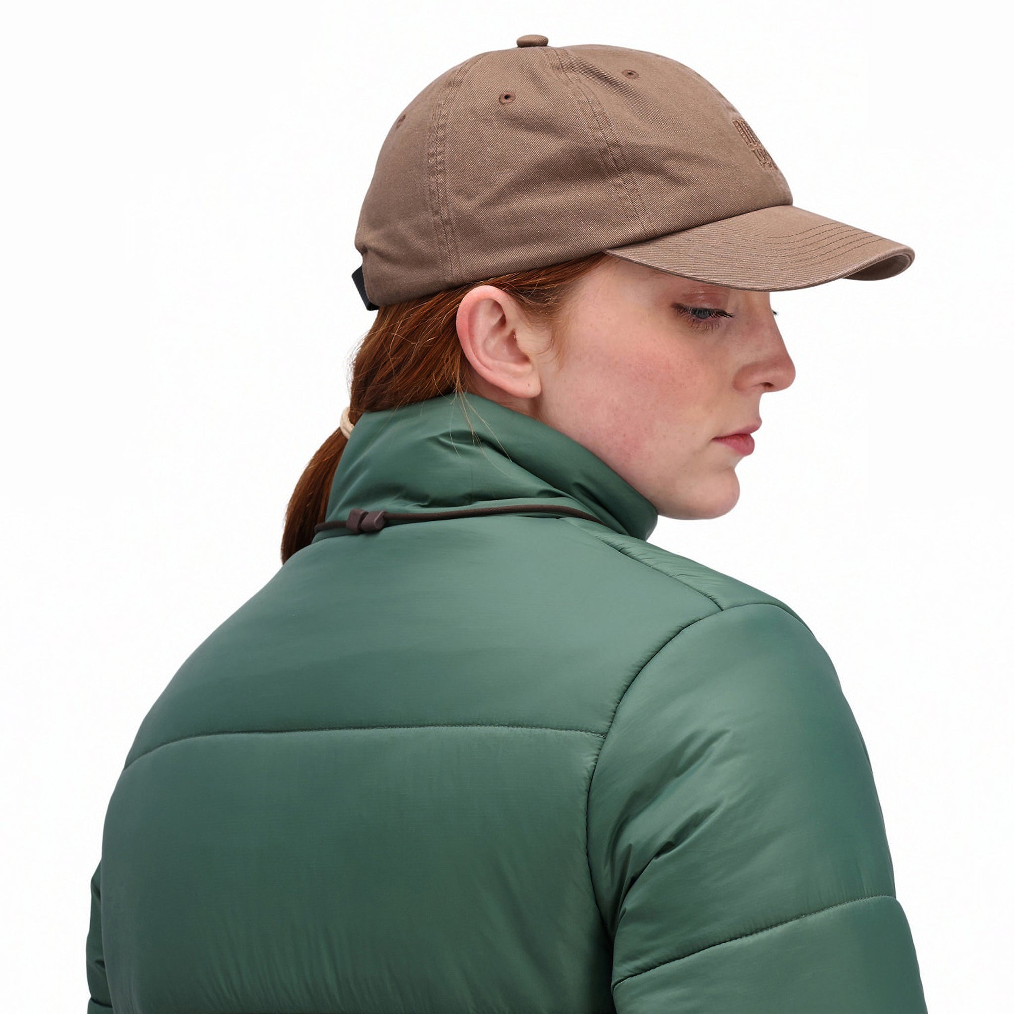 Rückseitige Modellaufnahme der Topo Designs Damen Puffer recycelte isolierte Jacke in "Forest" grün mit Kragen.