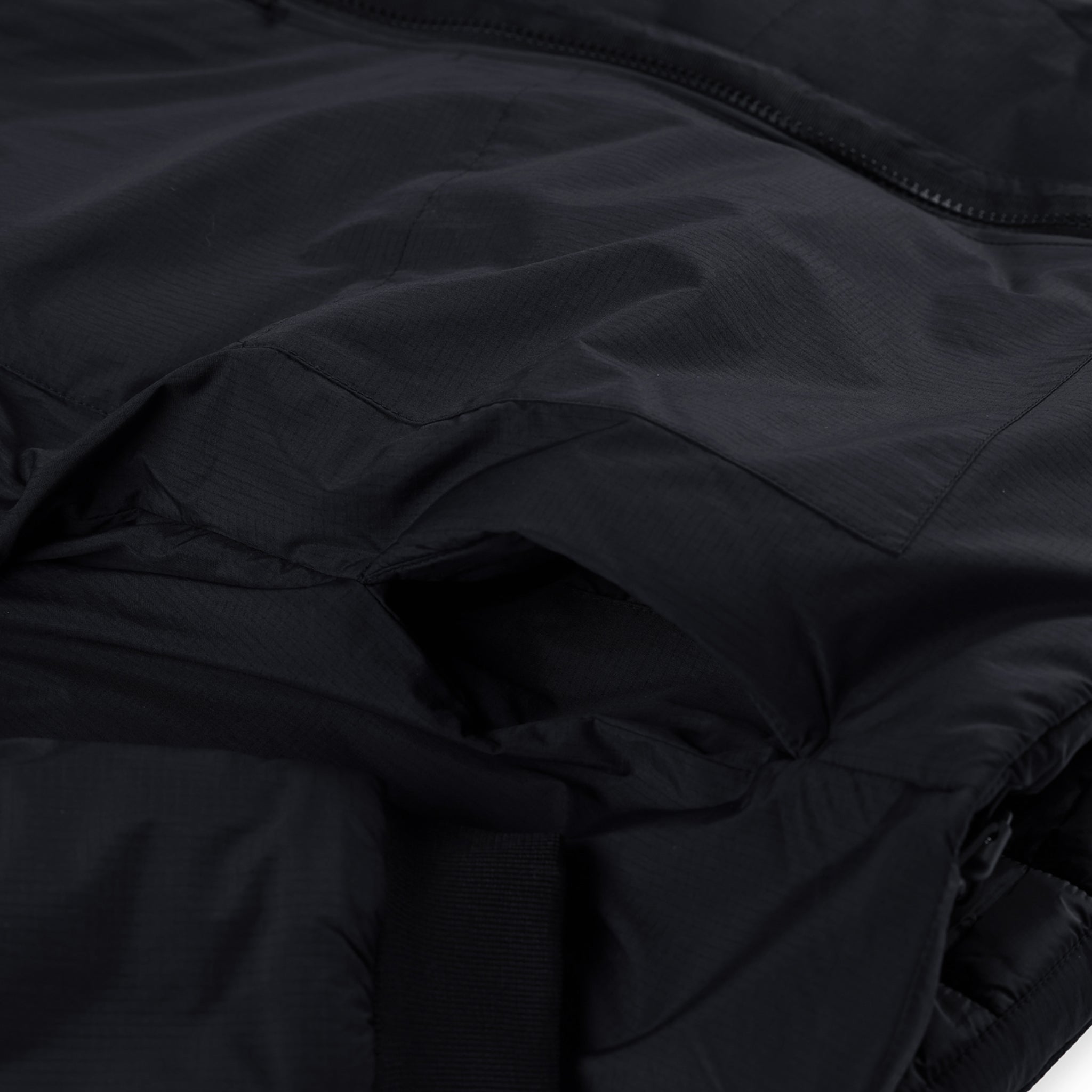 Detailaufnahme der Eingrifftaschen der Topo Designs Damen Puffer Primaloft insulated Hoodie Jacke in "black".