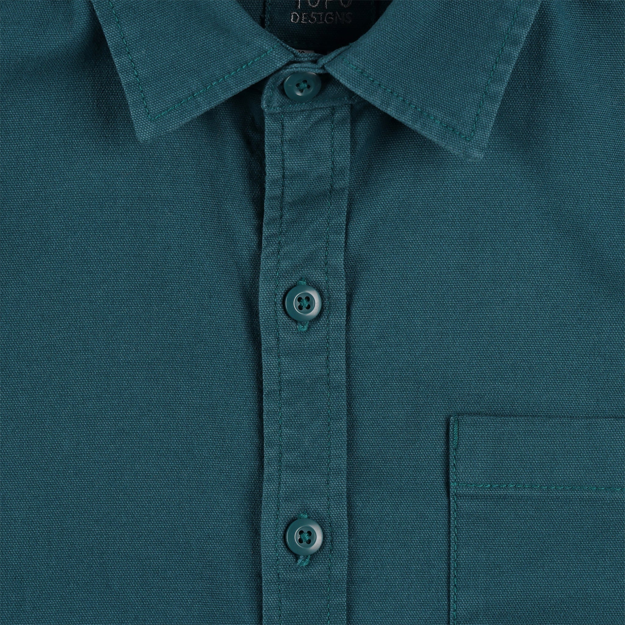 Gesamtaufnahme des Topo Designs Herren Short Sleeve Dirt Shirt in pond blue mit Nahaufnahme von Kragen, Knöpfen und Karotasche.