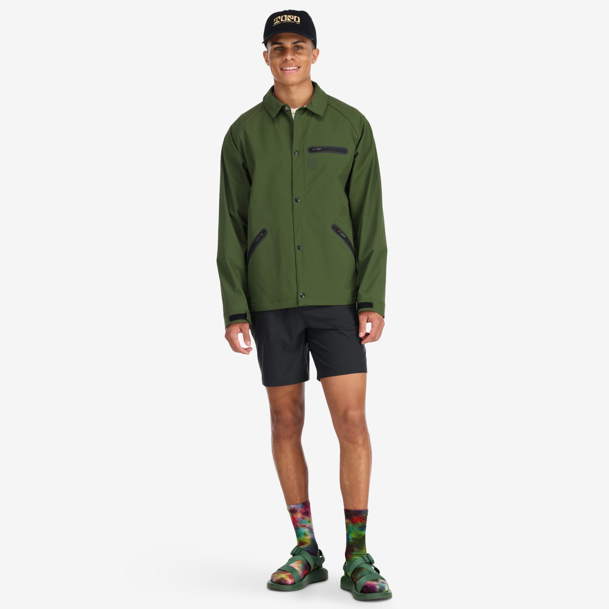 Allgemeine Aufnahme des Models, das die Topo Designs Herren Tech Breaker Jacket 4-Wege-Stretch-Windjacke in Olivgrün trägt.