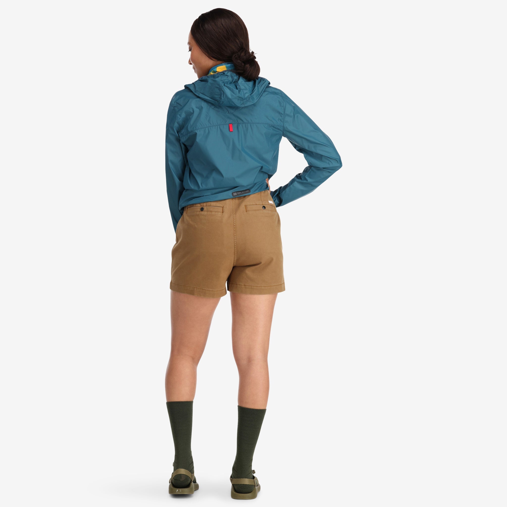 Allgemeine Rückenaufnahme des Models, das die Topo Designs Damen Mountain Shorts aus Bio-Baumwolle in dunklem Khakibraun trägt.