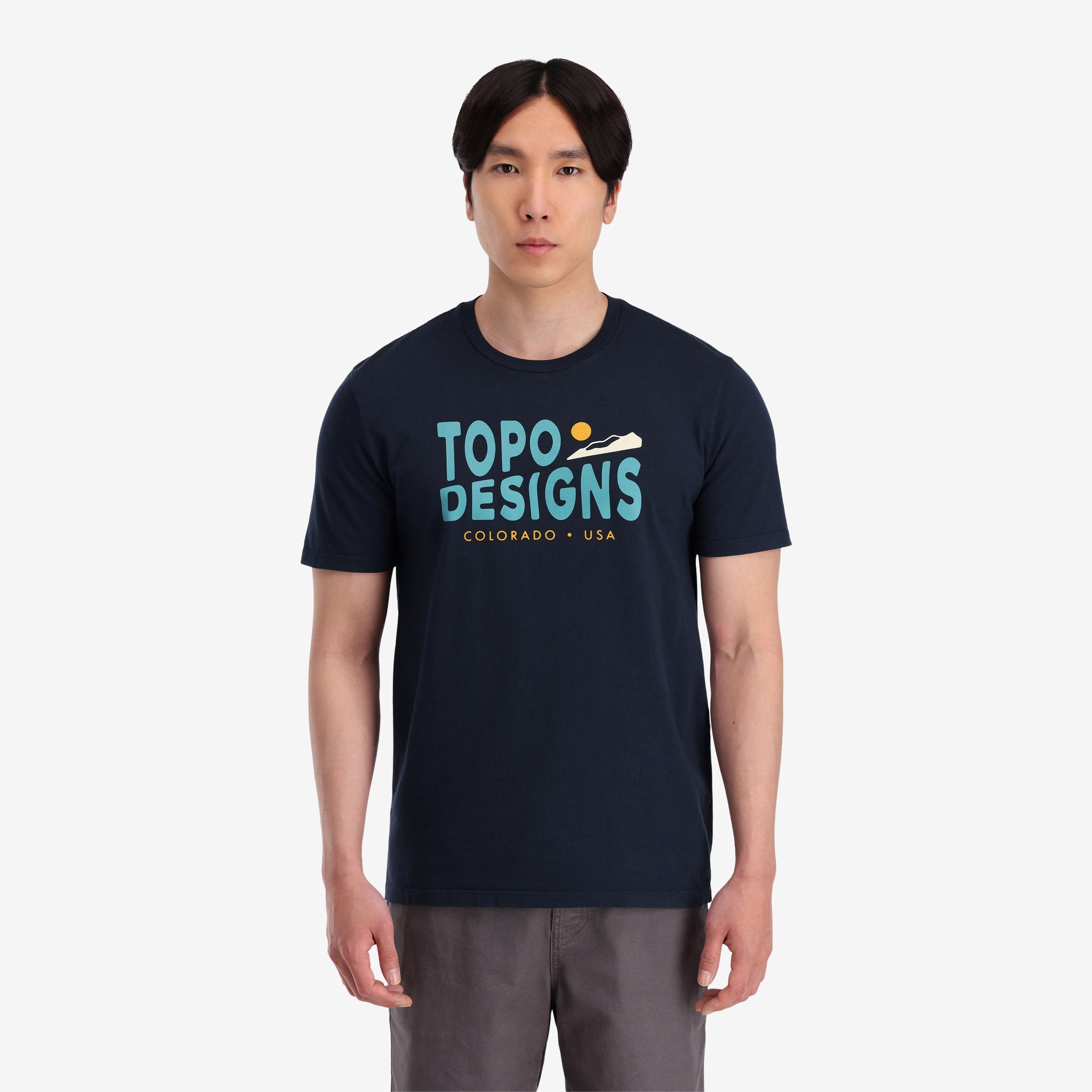 Allgemeine Aufnahme Auf Modell Vorderansicht von Topo Designs Herren Small Diamond Tee 100% Bio-Baumwolle Kurzarm-Grafik-Logo-T-Shirt in "navy" blau.