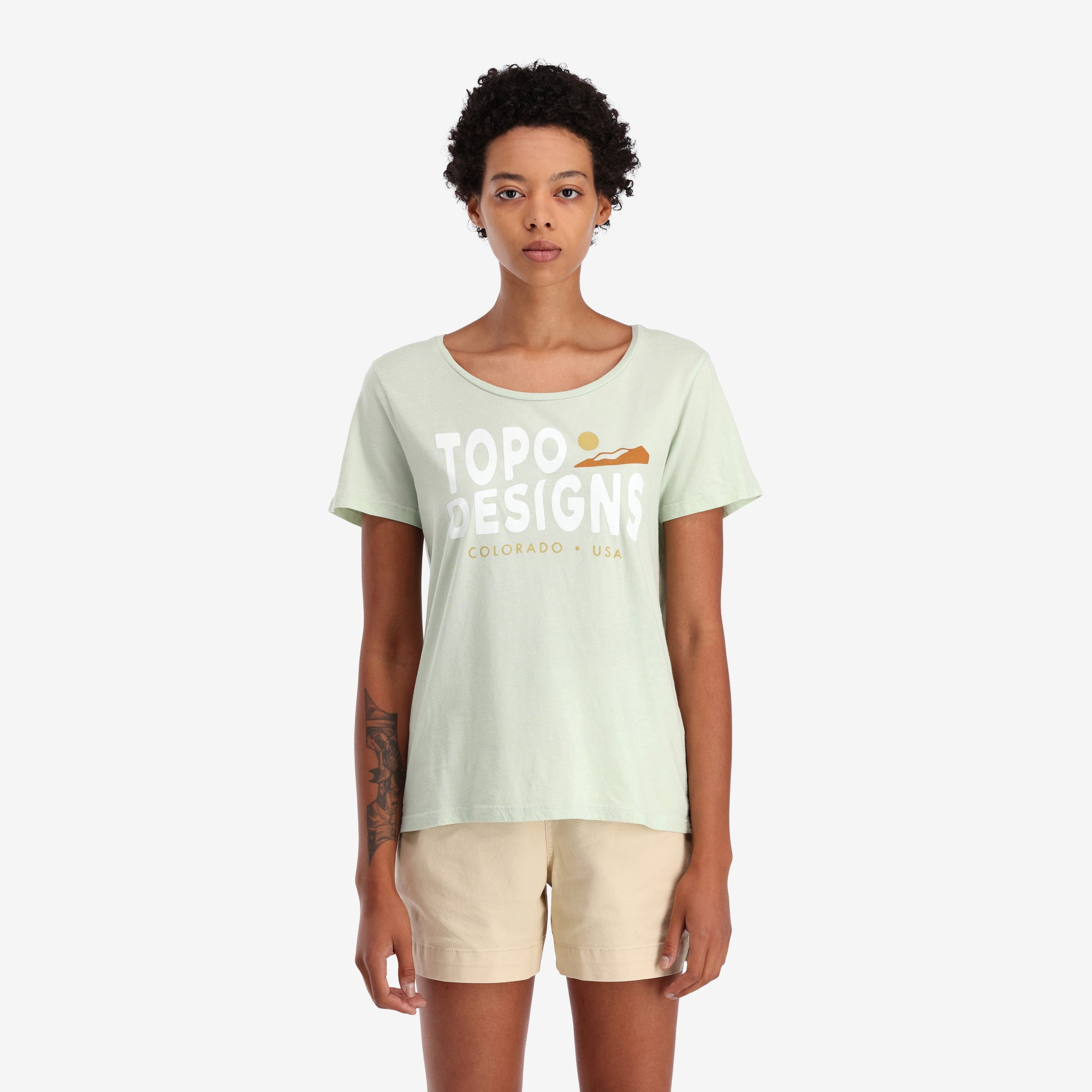 Allgemeine Aufnahme Auf Modell Vorderansicht von Topo Designs Damen Sunrise Tee 100% Bio-Baumwolle Kurzarm-Grafik-Logo-T-Shirt in "Light Mint" grün...