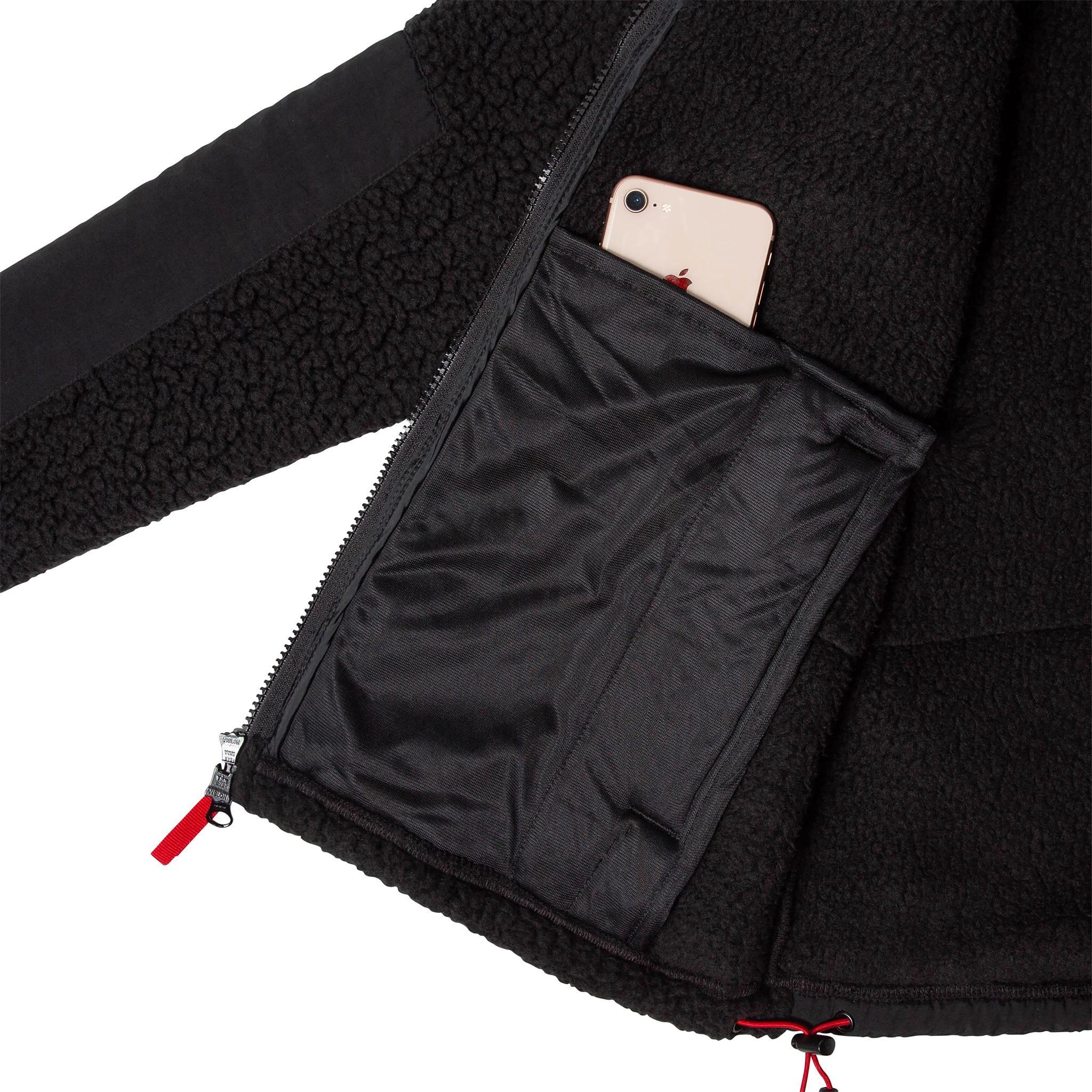 Allgemeine Detailaufnahme des Herren Subalpine Fleece in Schwarz mit Details der Innentaschen.