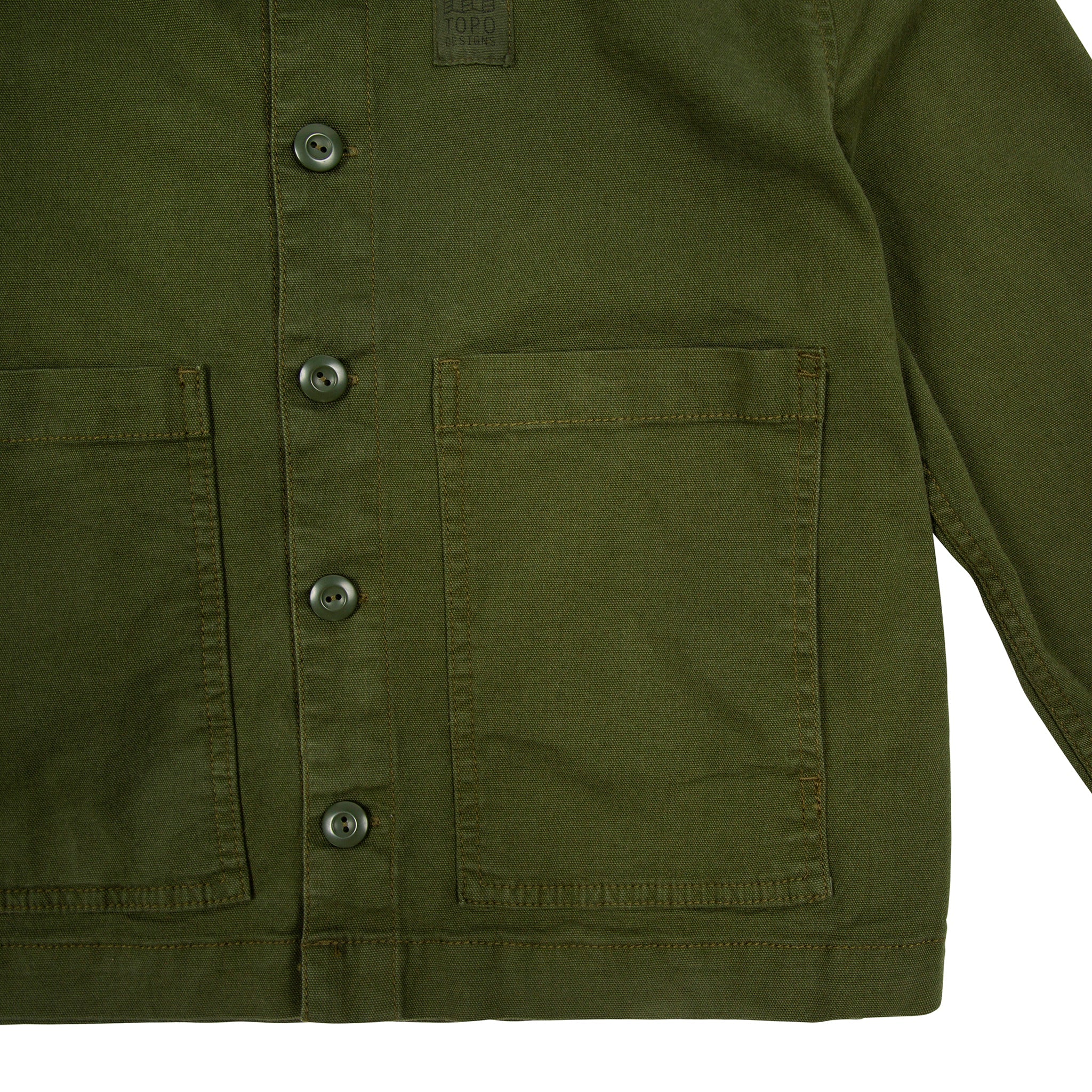 Détail général de laVeste Topo Designs Femmes Dirt Veste en vert olive montrant les poches avant et les boutons.