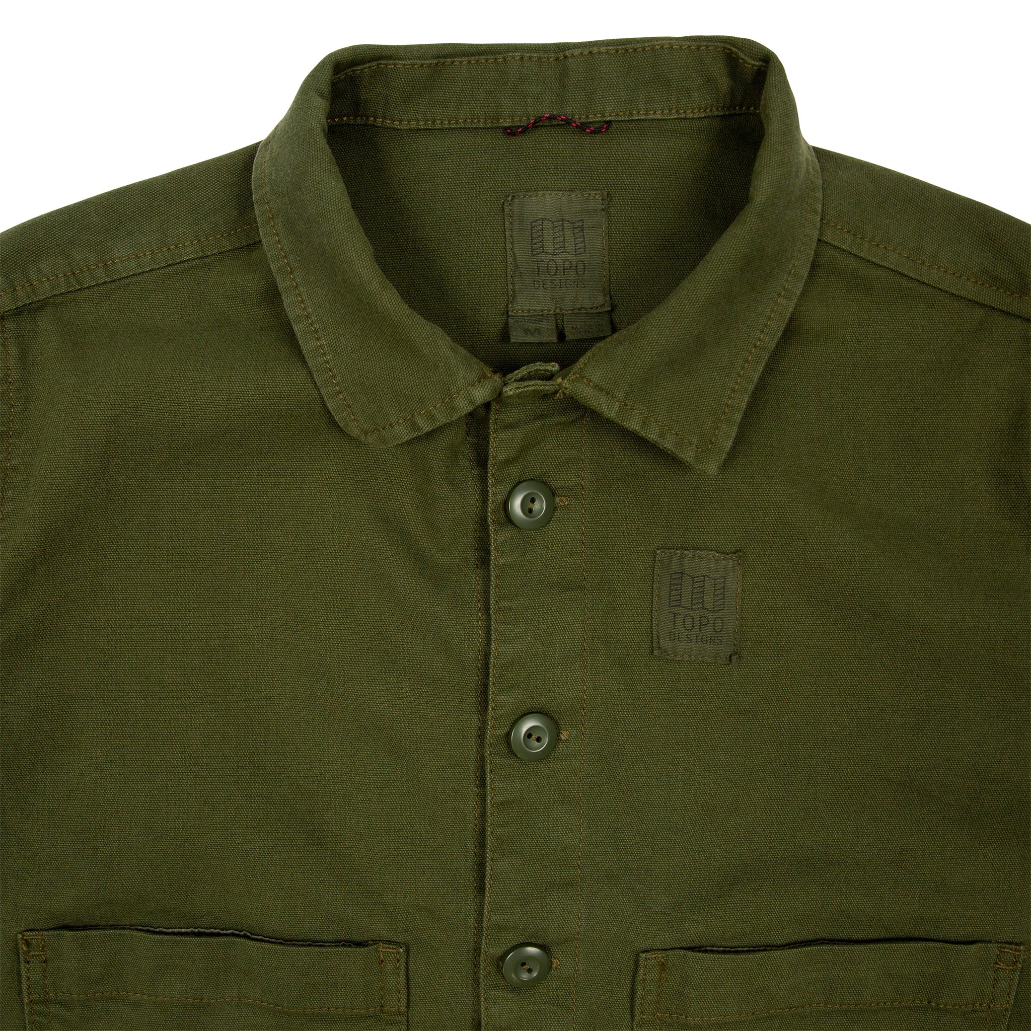 Vue d'ensemble de laVeste Topo Designs Femmes Dirt  en vert olive montrant le col, l'étiquette intérieure, le logo sur la poitrine et les boutons.