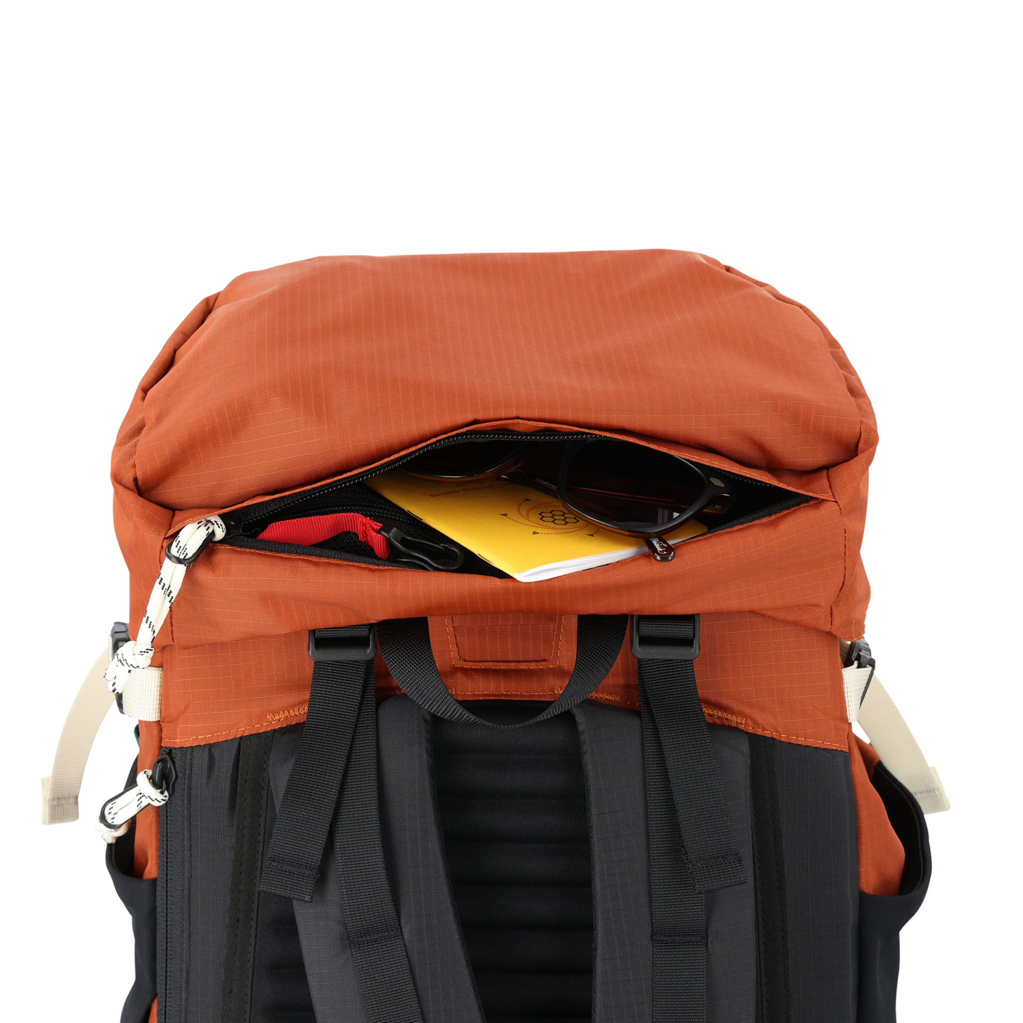 Vue générale du compartiment zippé supérieur et de l'attache-clé du sac à dos de randonnée Topo Designs Mountain Pack 28L avec accès à la pochette externe pour ordinateur portable en nylon léger recyclé orange noir.