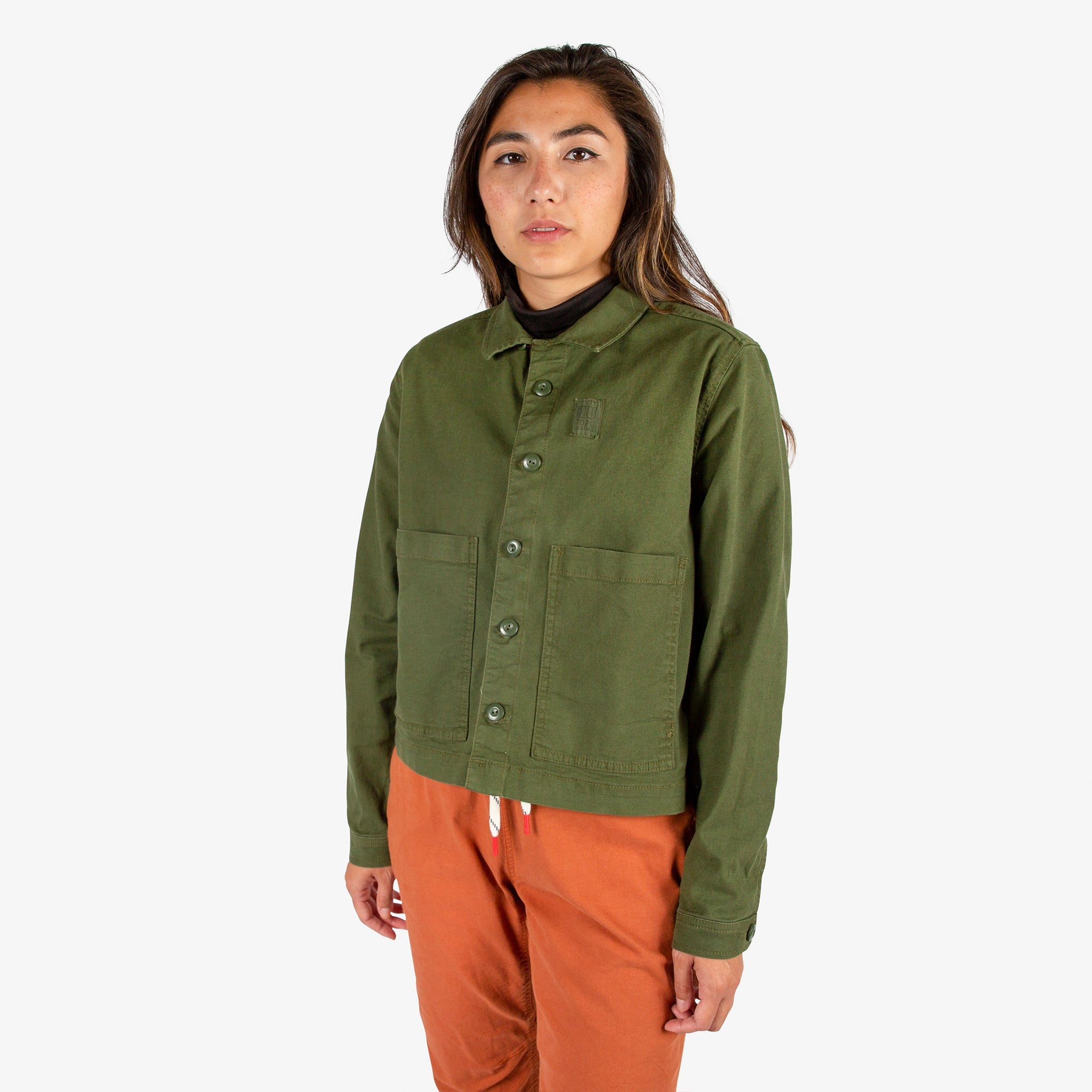 Modèle de face de laVeste Topo Designs Femmes Dirt  en vert "Olive" et duPantalon  Dirt  en orange Brick.