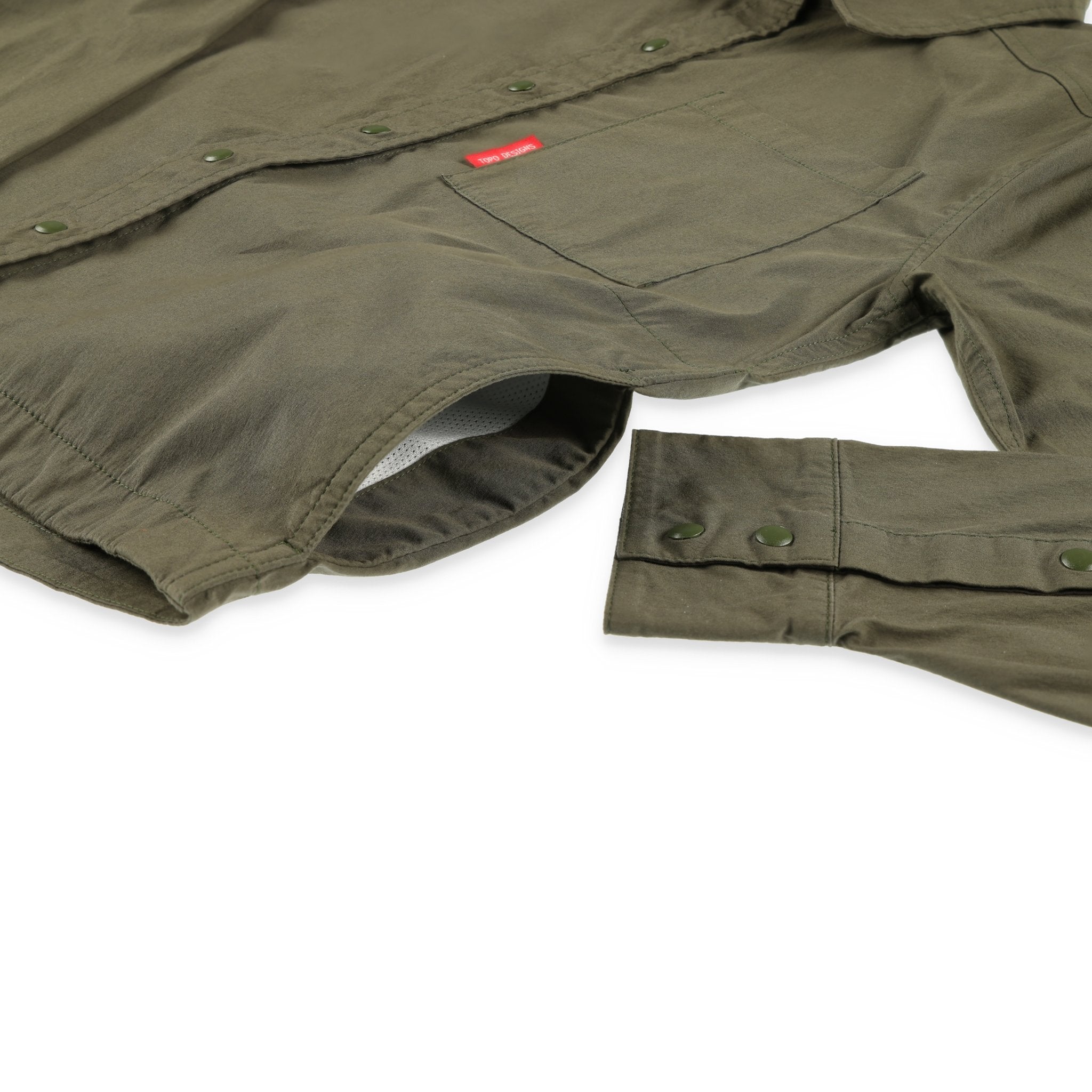 Vue générale de la Chemise voyage Topo Designs Femmes Global Manches Longues en vert olive, montrant les poches latérales pour les mains.